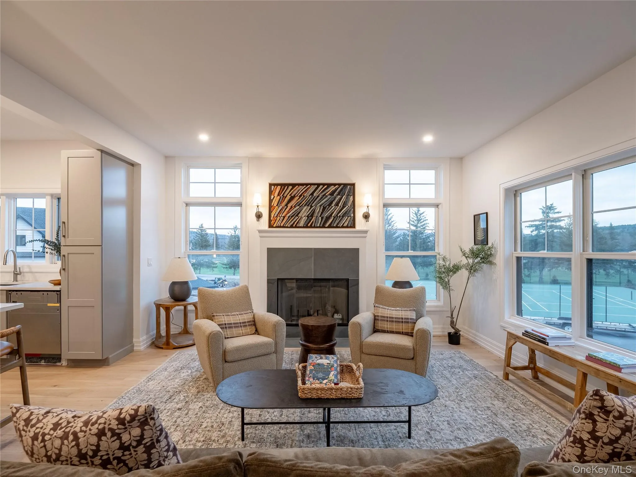 Living area featuring light wood-type flooring, healthy amount of natural light, a fireplace, and recessed lighting Living area featuring light wood-type flooring, healthy amount of natural light, a fireplace, and recessed lighting