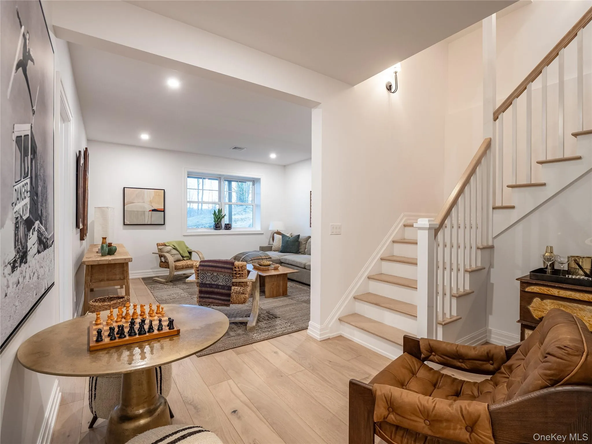 Living area featuring stairs, light wood-style floors, and recessed lighting Living area featuring stairs, light wood-style floors, and recessed lighting