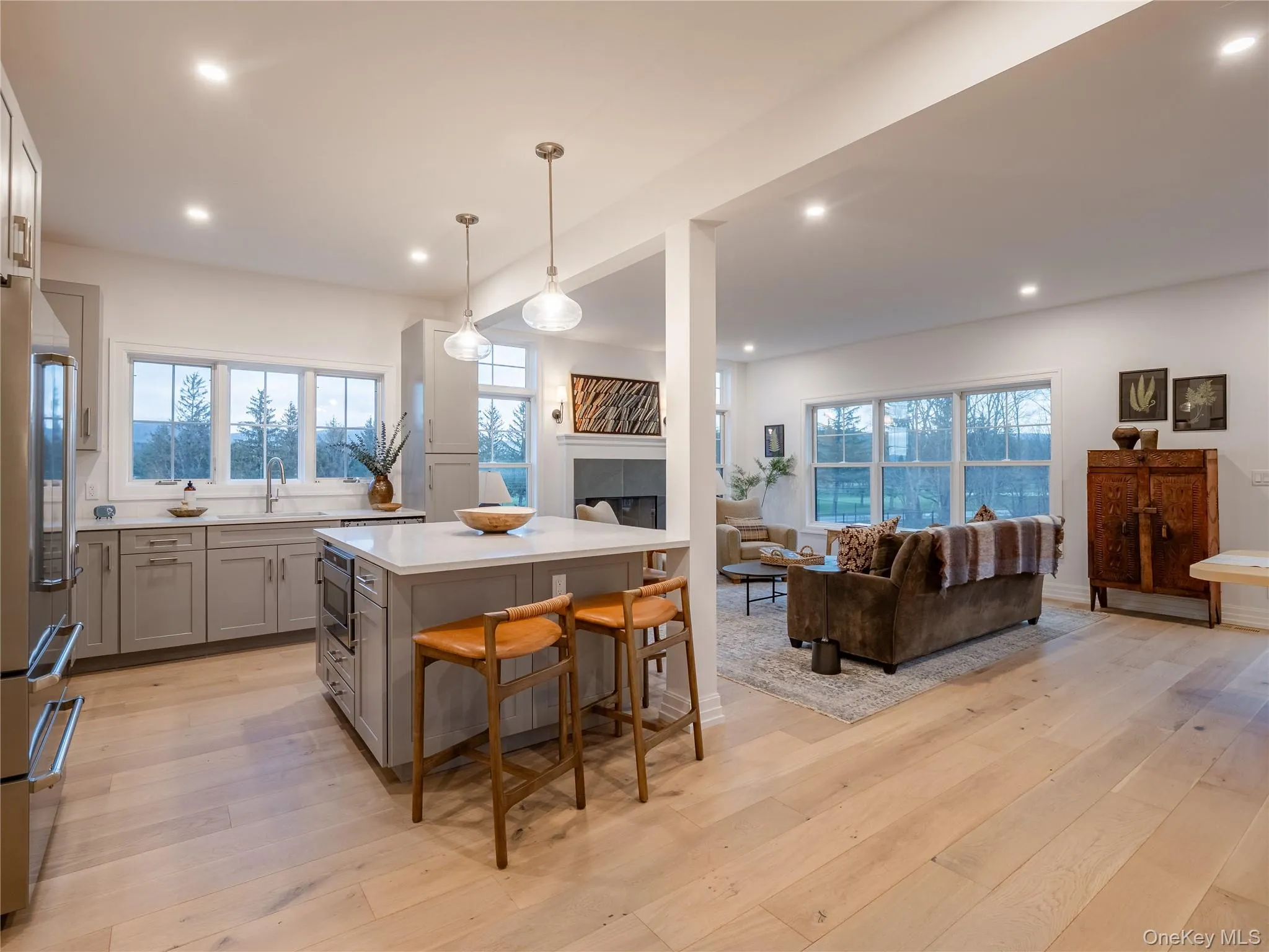 Kitchen featuring open floor plan, a center island, light wood-type flooring, a kitchen bar, and recessed lighting Kitchen featuring open floor plan, a center island, light wood-type flooring, a kitchen bar, and recessed lighting