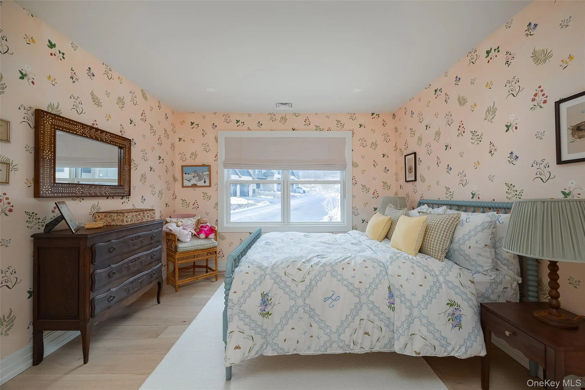 Bedroom with light wood-type flooring and wallpapered walls Bedroom with light wood-type flooring and wallpapered walls
