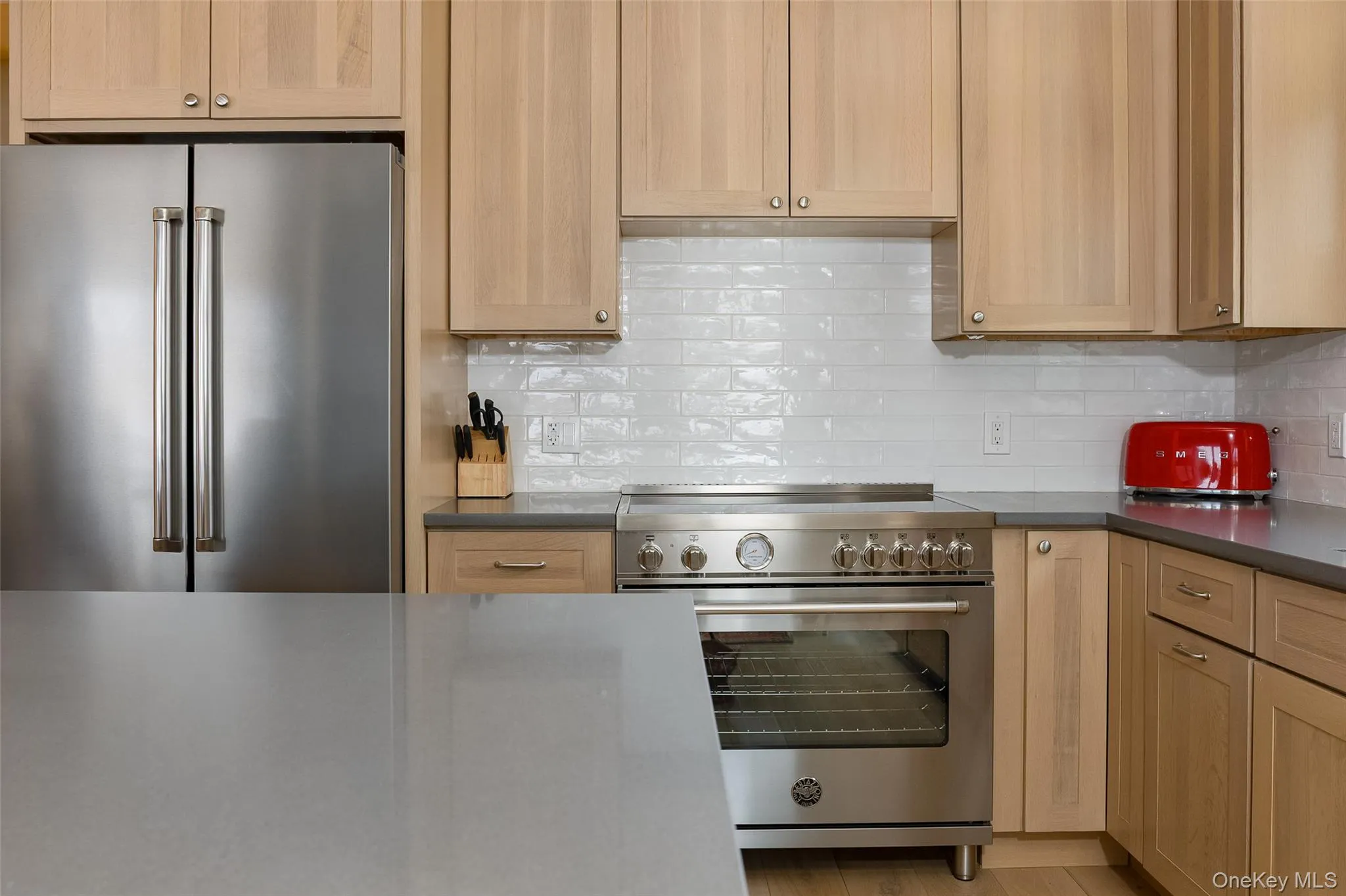 Kitchen with premium appliances, tasteful backsplash, and light brown cabinets Kitchen with premium appliances, tasteful backsplash, and light brown cabinets