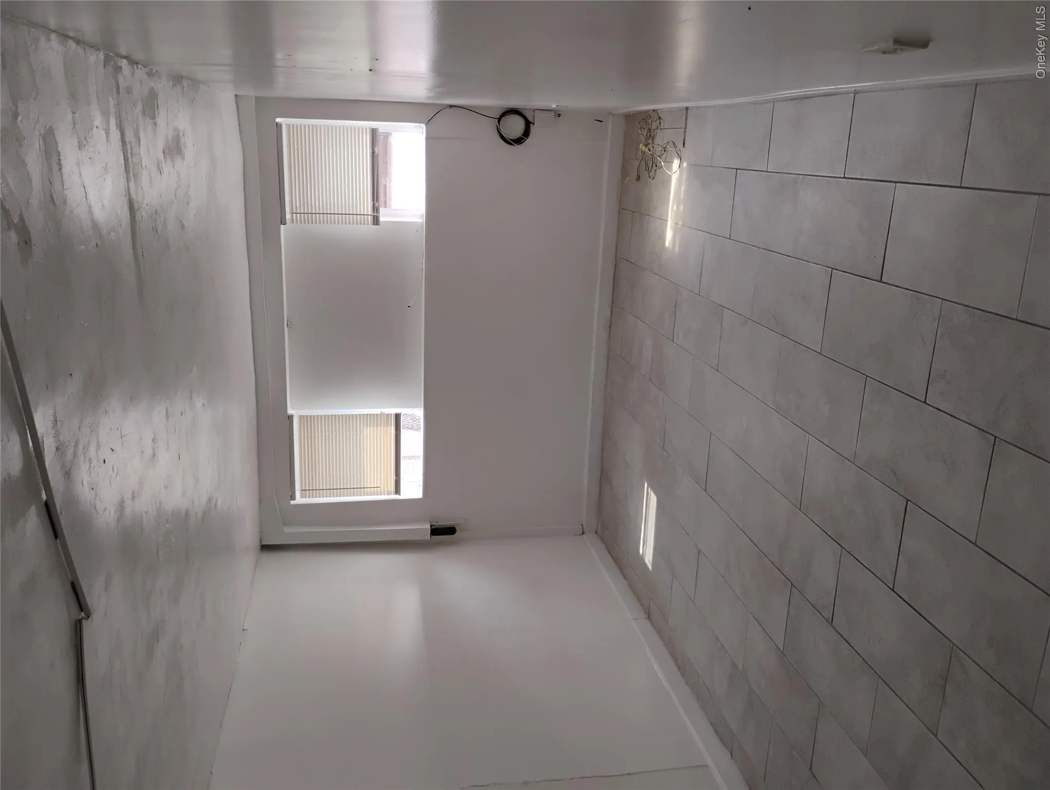 Rectangular tile flooring with a matte finish, white painted walls, and window treatments Rectangular tile flooring with a matte finish, white painted walls, and window treatments