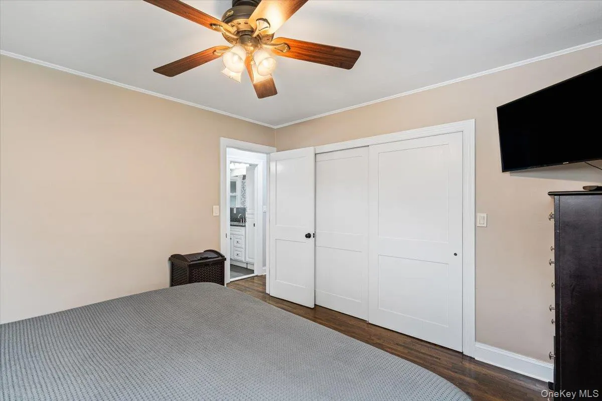 Hardwood-style flooring, a ceiling fan with integrated lighting, and white trim detailing Hardwood-style flooring, a ceiling fan with integrated lighting, and white trim detailing