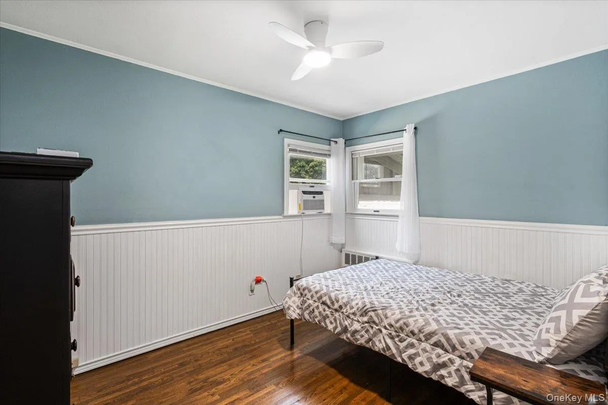Hardwood flooring, beadboard wainscoting, and a ceiling fan with integrated lighting Hardwood flooring, beadboard wainscoting, and a ceiling fan with integrated lighting