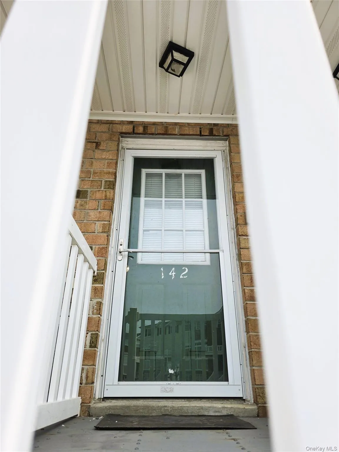 Brick exterior with white trim, white storm door, and recessed lighting Brick exterior with white trim, white storm door, and recessed lighting