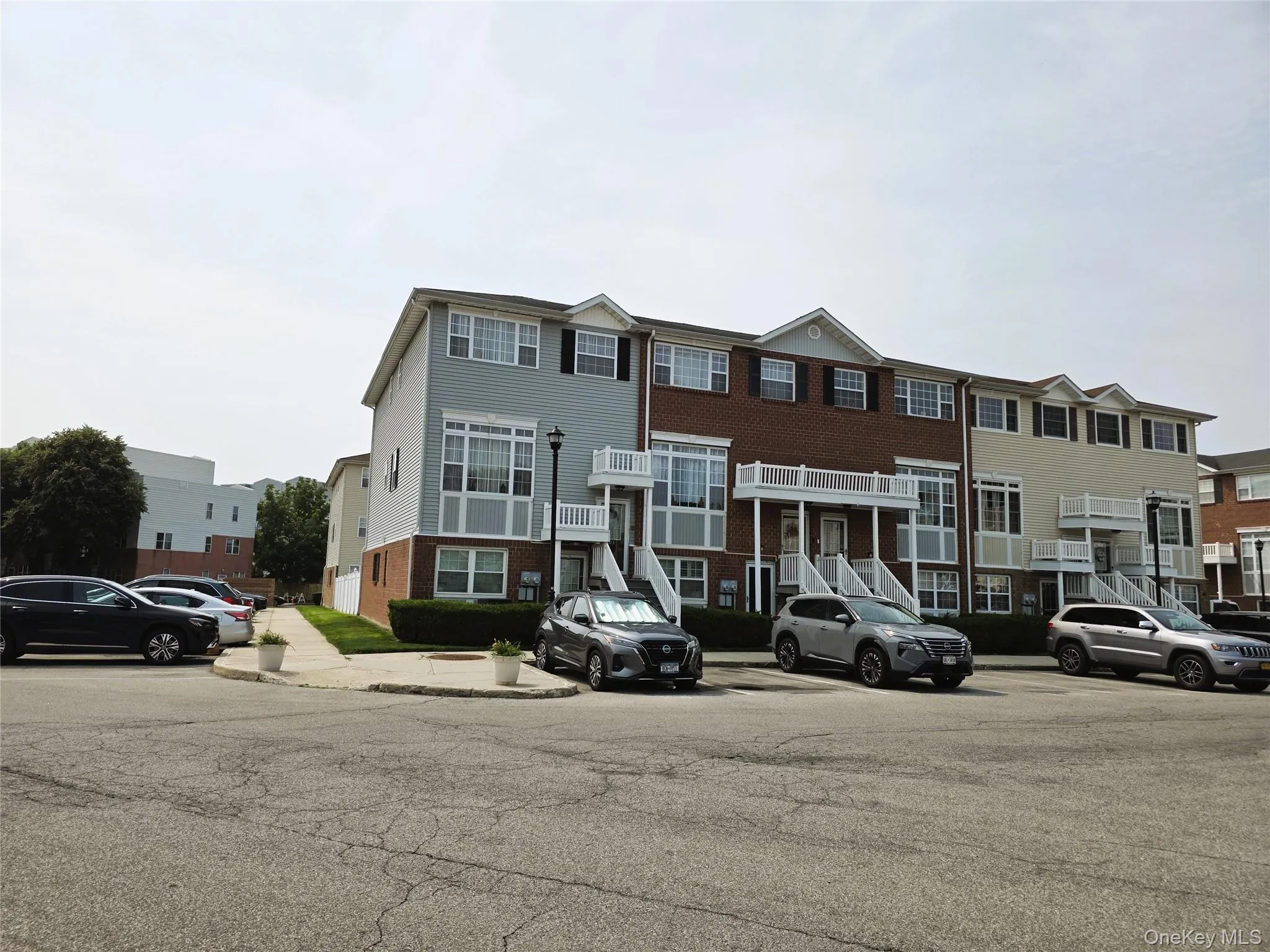 Three-story townhome with balconies, brick and siding exterior, and individual entrances Three-story townhome with balconies, brick and siding exterior, and individual entrances
