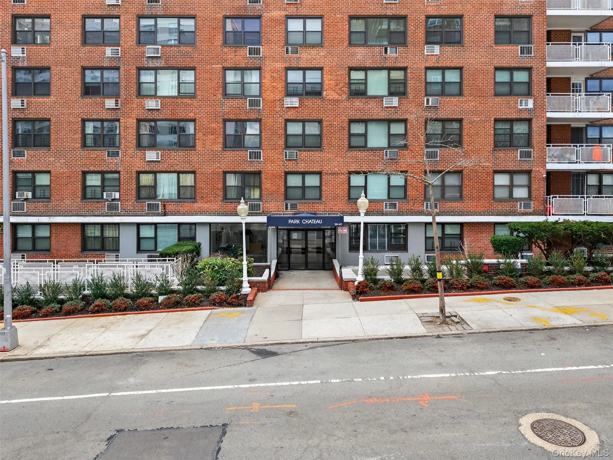 Classic brick mid-rise featuring a symmetrical facade with regularly spaced windows across multiple stories Classic brick mid-rise featuring a symmetrical facade with regularly spaced windows across multiple stories