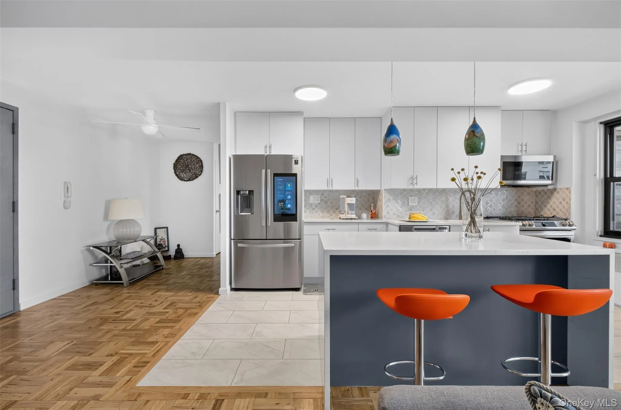 Modern kitchen featuring white cabinetry, stainless steel appliances, and a tiled backsplash Modern kitchen featuring white cabinetry, stainless steel appliances, and a tiled backsplash