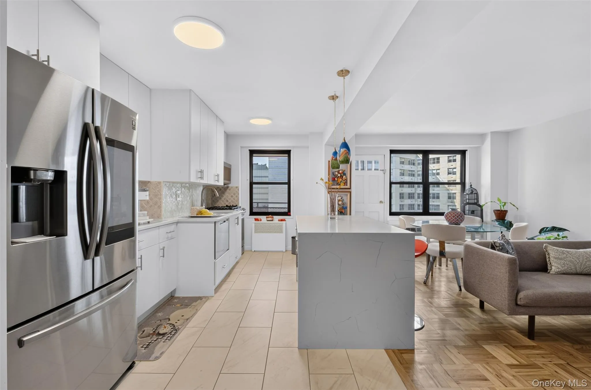 Open-concept kitchen featuring stainless steel appliances, white cabinetry, and an island with counter seating Open-concept kitchen featuring stainless steel appliances, white cabinetry, and an island with counter seating