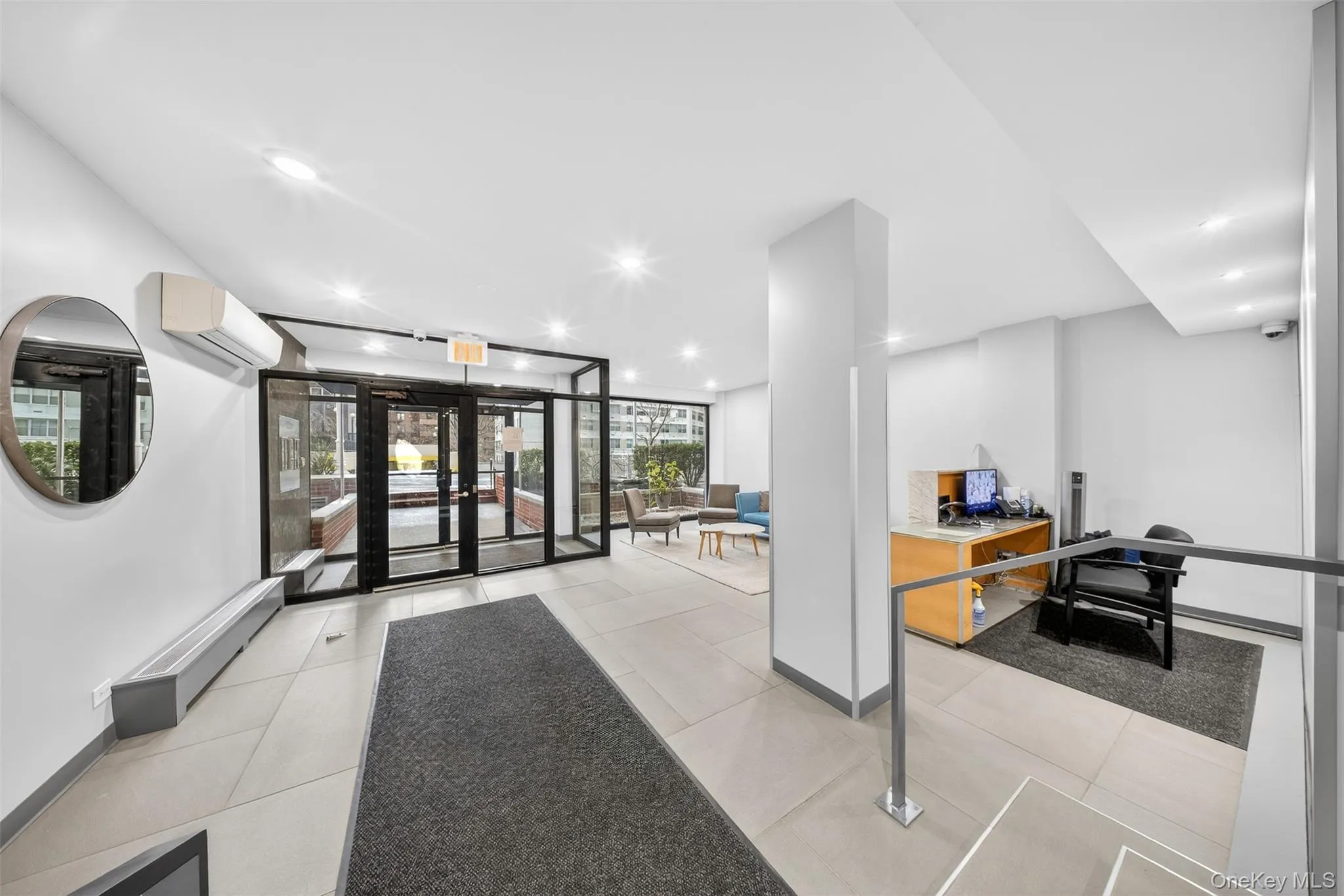 Lobby area featuring light-toned tile flooring, recessed lighting, and a glass-paneled entry Lobby area featuring light-toned tile flooring, recessed lighting, and a glass-paneled entry