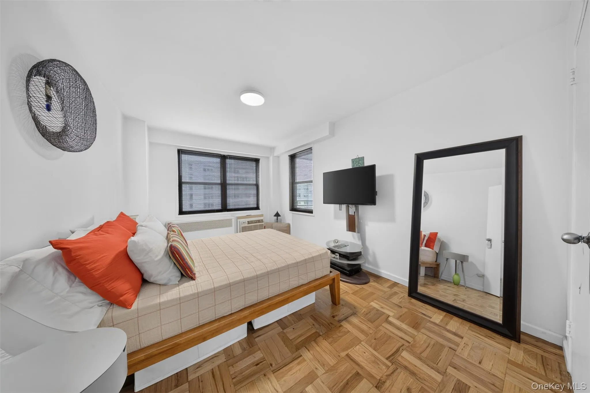 Parquet wood-finish flooring, white painted walls, recessed ceiling lighting, and large windows with horizontal blinds Parquet wood-finish flooring, white painted walls, recessed ceiling lighting, and large windows with horizontal blinds