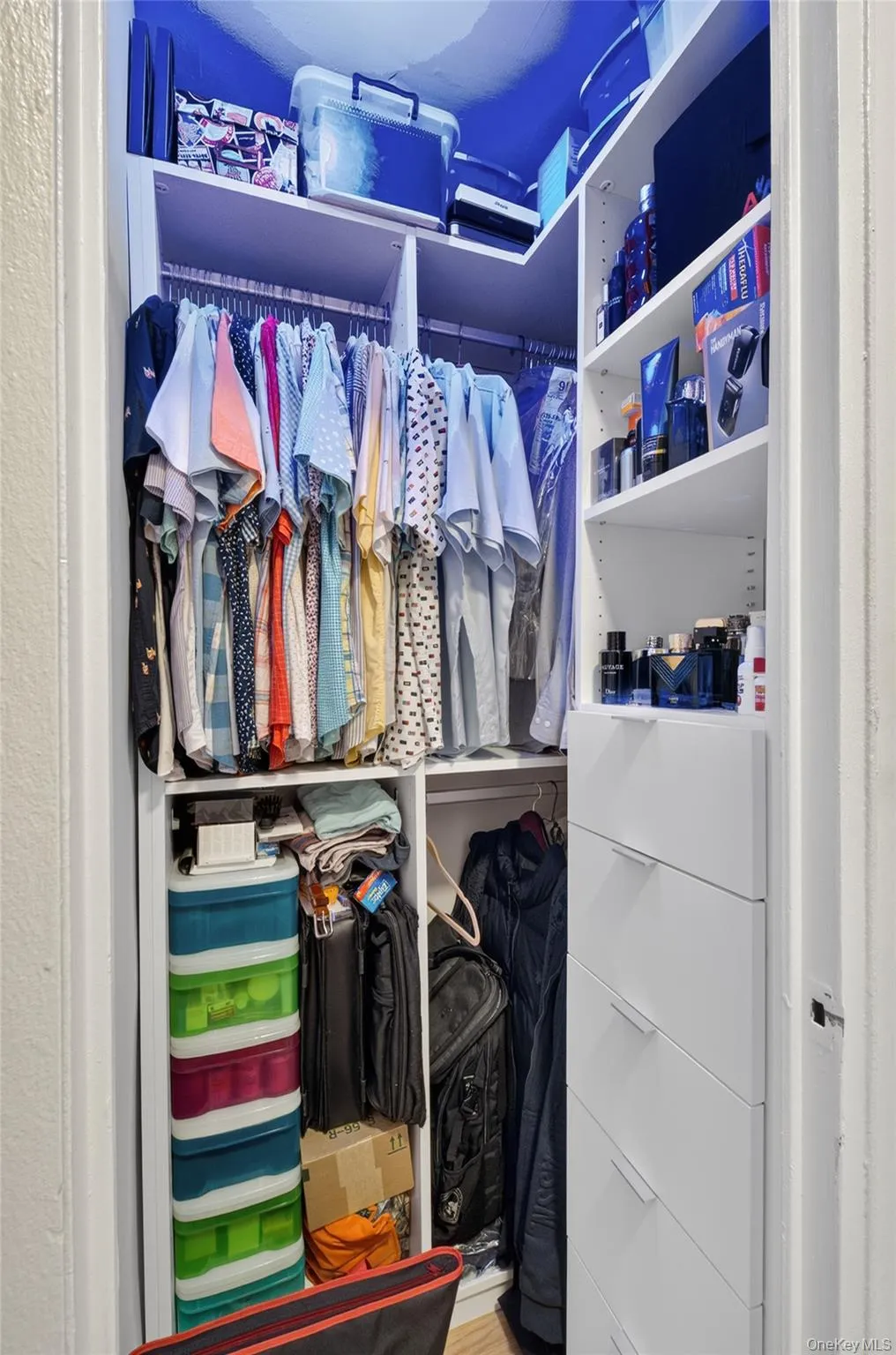 Built-in closet organization system featuring hanging rods, shelving, and drawer units Built-in closet organization system featuring hanging rods, shelving, and drawer units