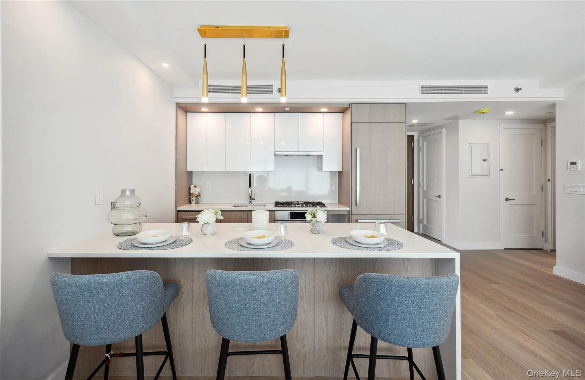 Kitchen with a breakfast bar, light countertops, a peninsula, modern cabinets, and recessed lighting Kitchen with a breakfast bar, light countertops, a peninsula, modern cabinets, and recessed lighting