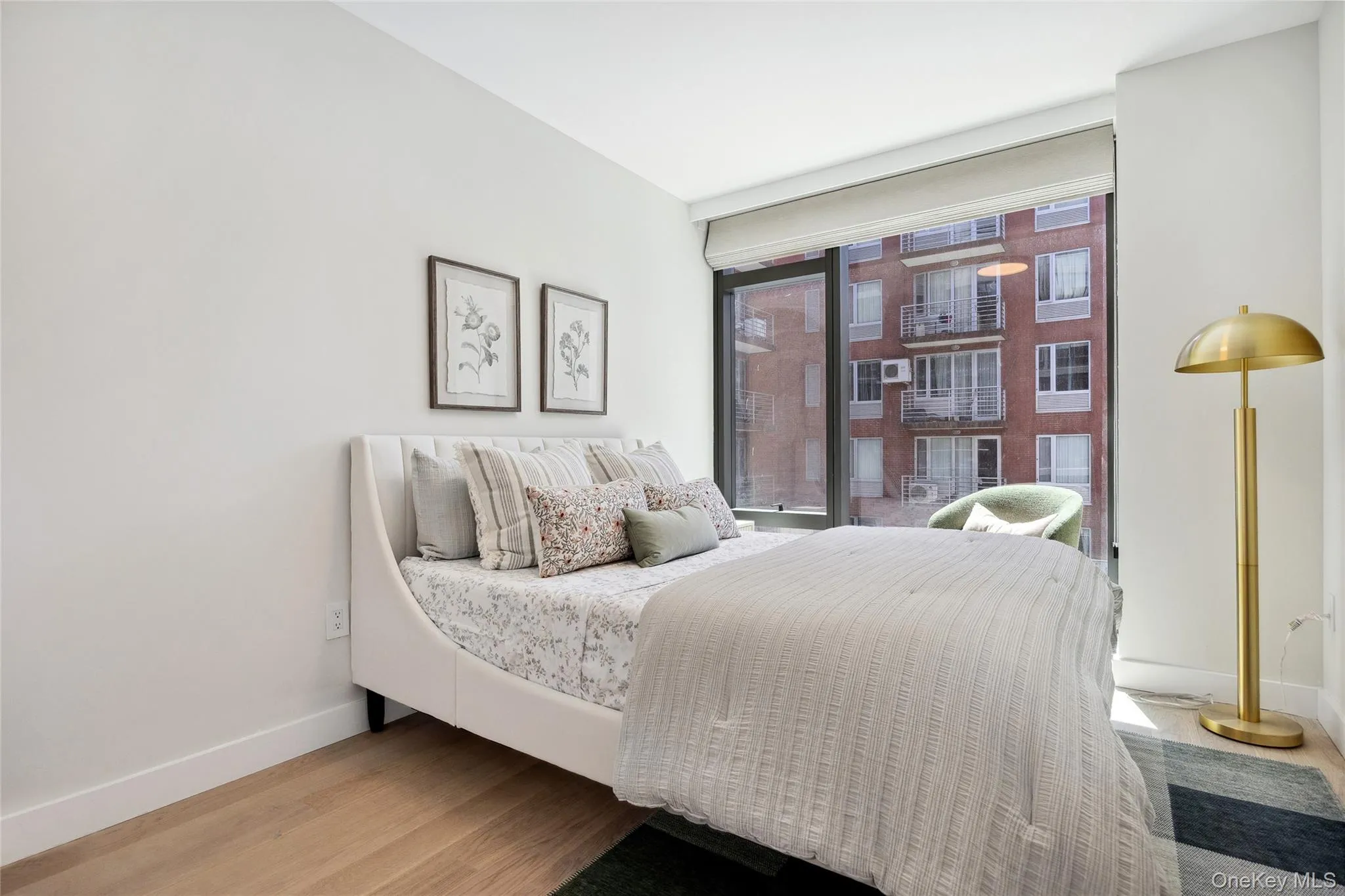 Bedroom featuring baseboards, wood finished floors, and floor to ceiling windows Bedroom featuring baseboards, wood finished floors, and floor to ceiling windows