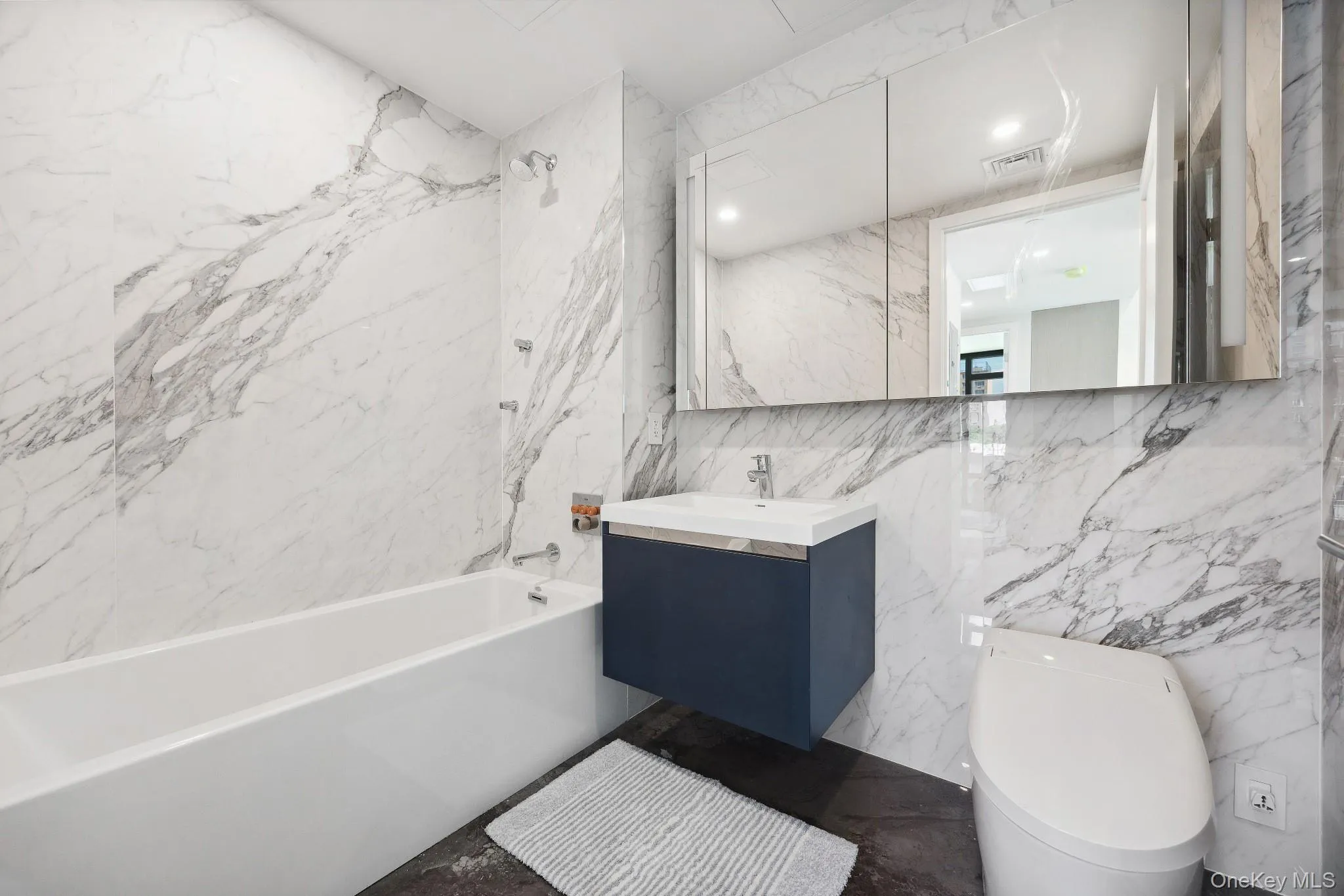 Full bathroom with tile walls, toilet, bathtub / shower combination, and vanity Full bathroom with tile walls, toilet, bathtub / shower combination, and vanity