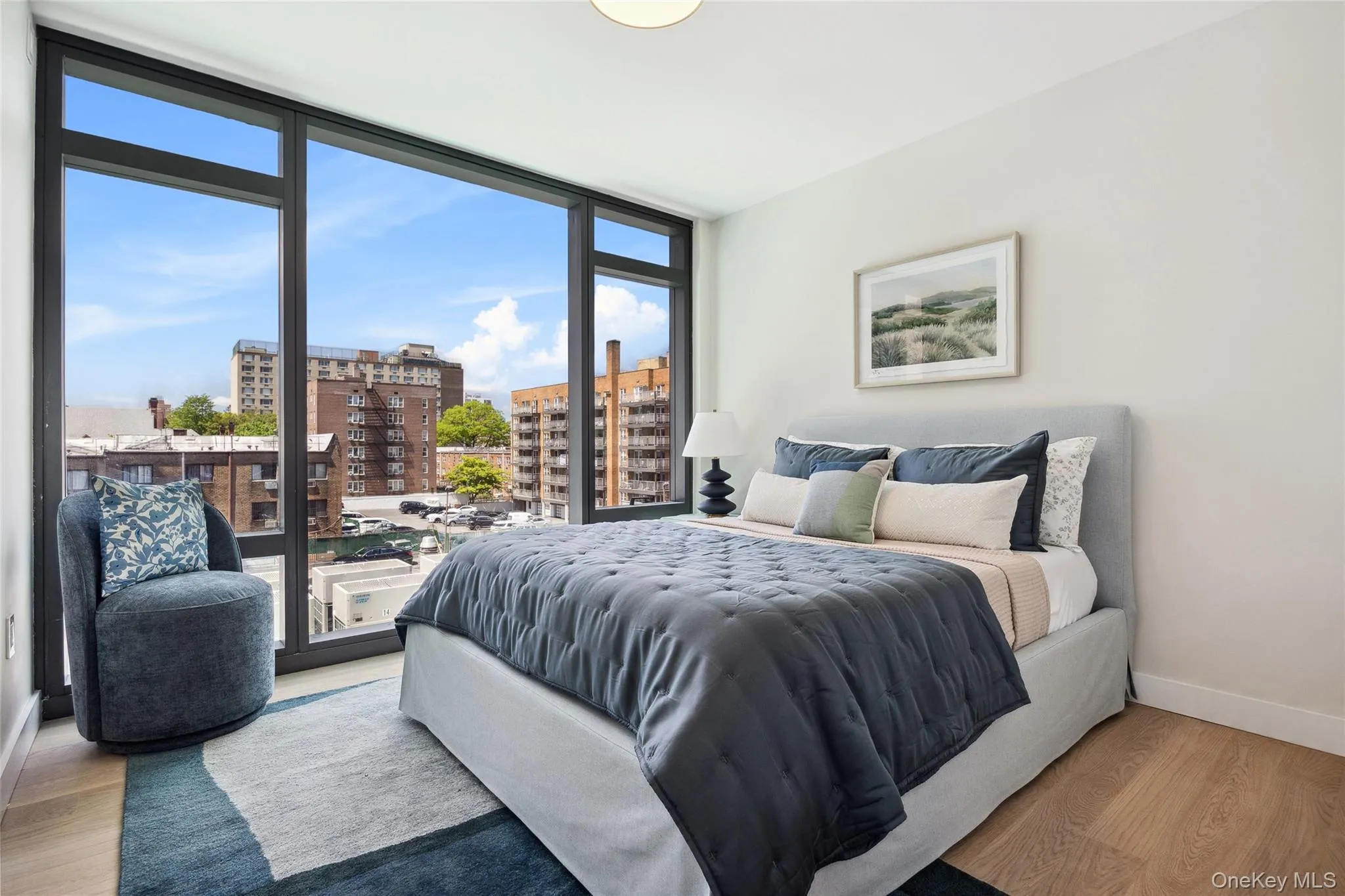 Bedroom featuring a view of city, wood finished floors, baseboards, expansive windows, and access to outside Bedroom featuring a view of city, wood finished floors, baseboards, expansive windows, and access to outside