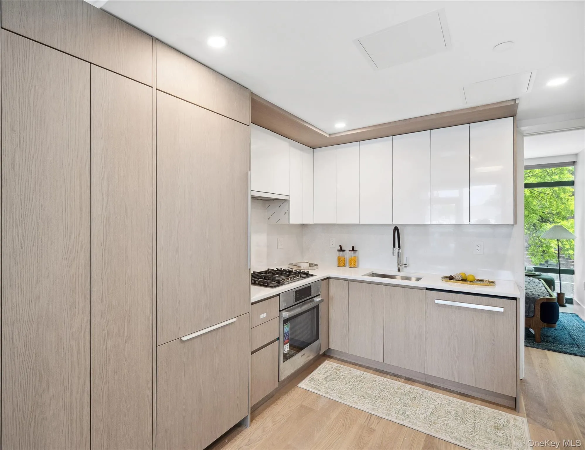 Kitchen featuring a sink, stainless steel appliances, light wood-style floors, light countertops, and recessed lighting Kitchen featuring a sink, stainless steel appliances, light wood-style floors, light countertops, and recessed lighting