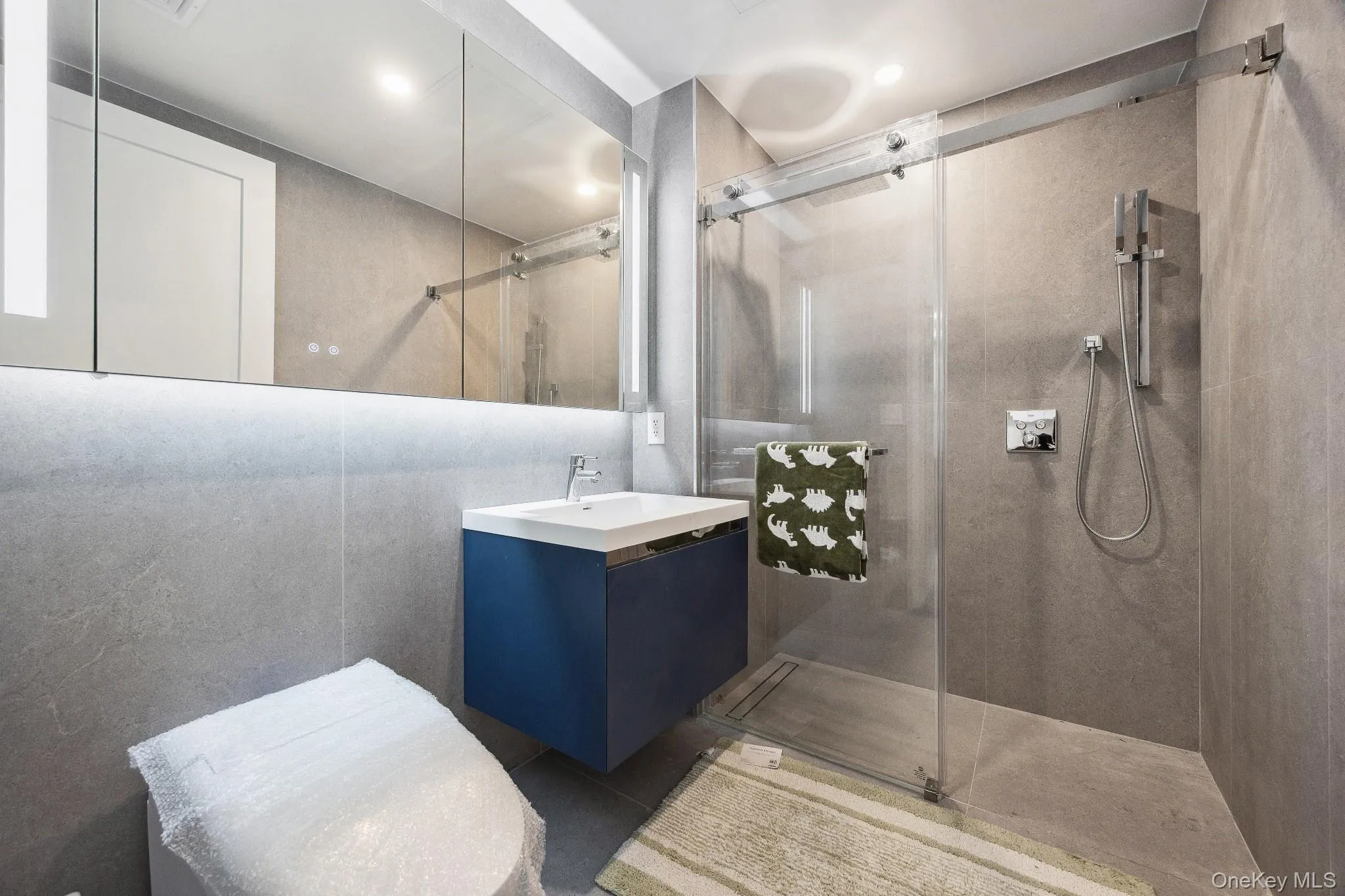 Bathroom featuring tiled shower and vanity Bathroom featuring tiled shower and vanity