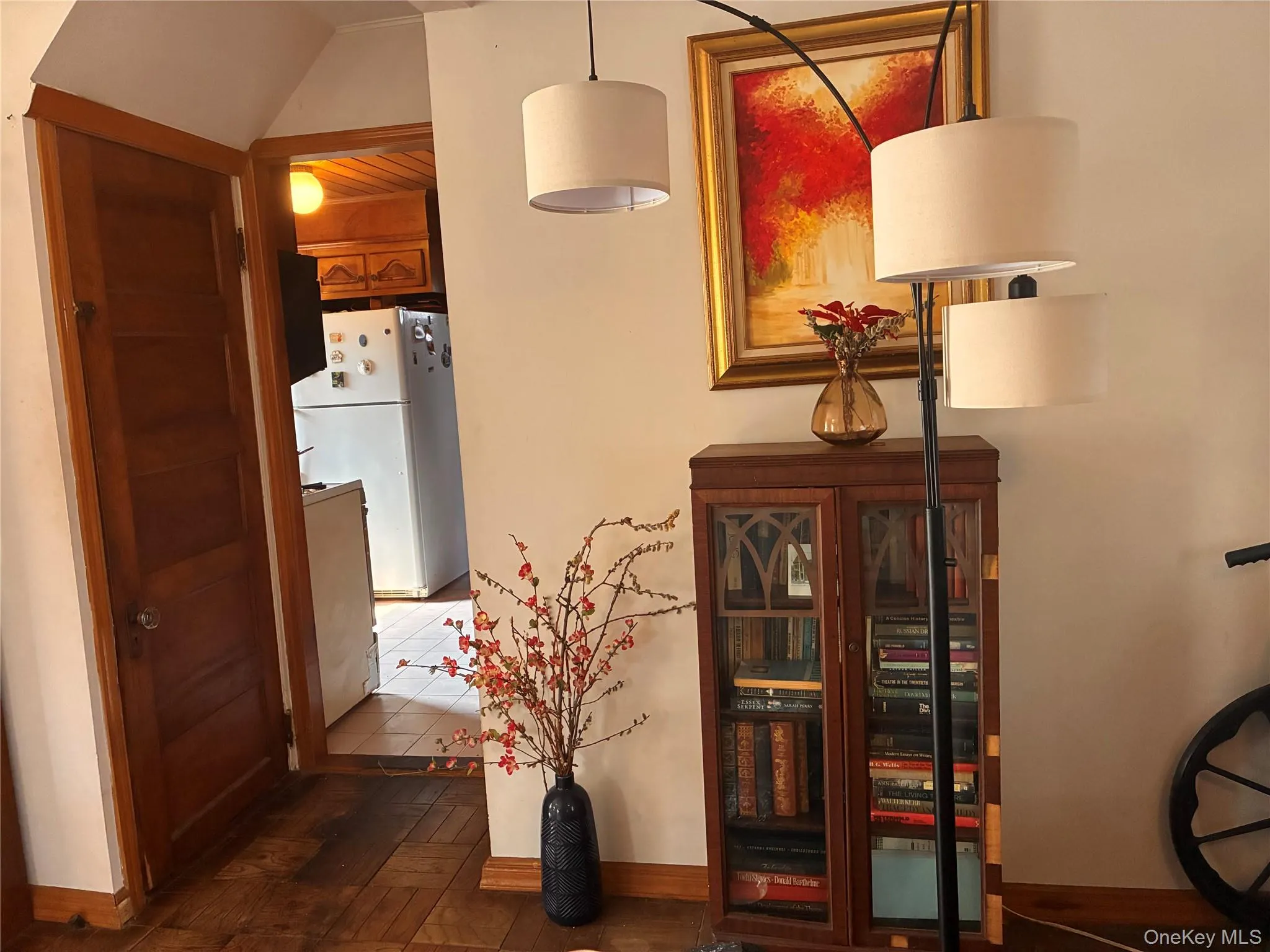 Wood-finish flooring with a decorative pattern, solid wood door, and a built-in wood cabinet with glass panel doors Wood-finish flooring with a decorative pattern, solid wood door, and a built-in wood cabinet with glass panel doors