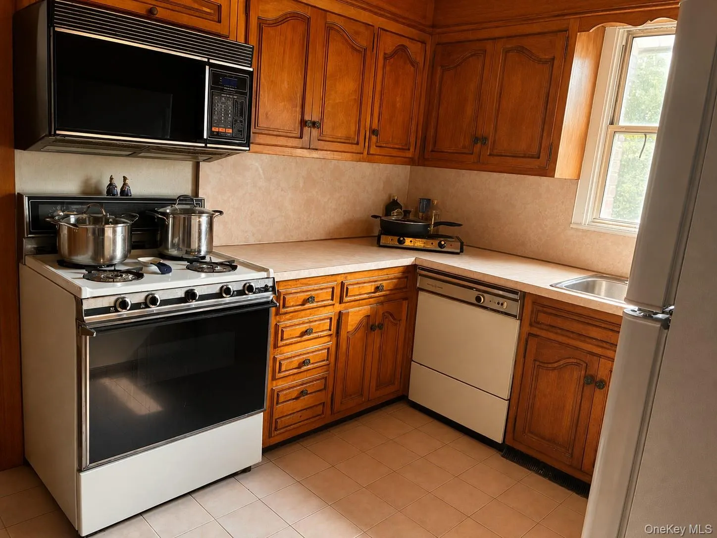 Kitchen featuring wood cabinetry, solid surface countertops, and an integrated stainless steel sink Kitchen featuring wood cabinetry, solid surface countertops, and an integrated stainless steel sink