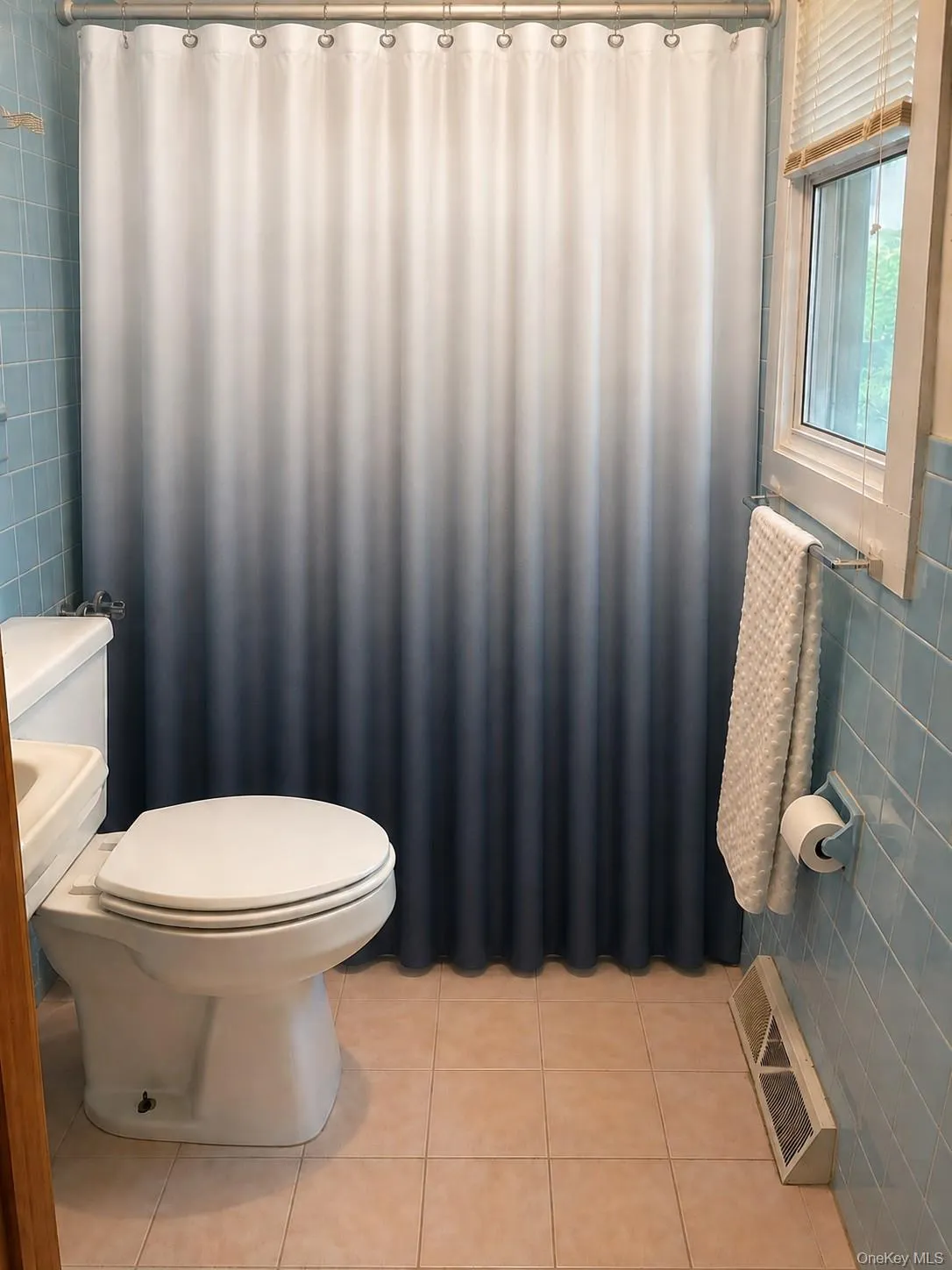 Recessed window with privacy blinds, ceramic tile flooring, and light blue wall tiling Recessed window with privacy blinds, ceramic tile flooring, and light blue wall tiling