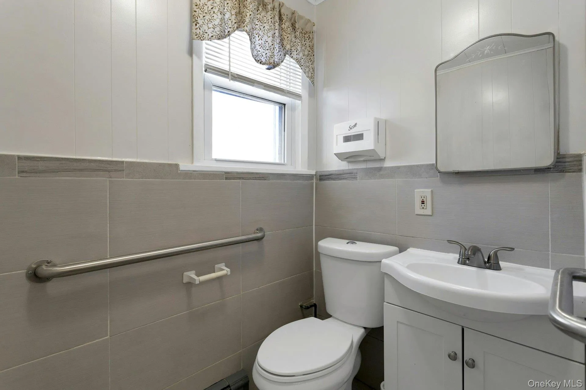 Bathroom with vanity, toilet, and tile walls Bathroom with vanity, toilet, and tile walls
