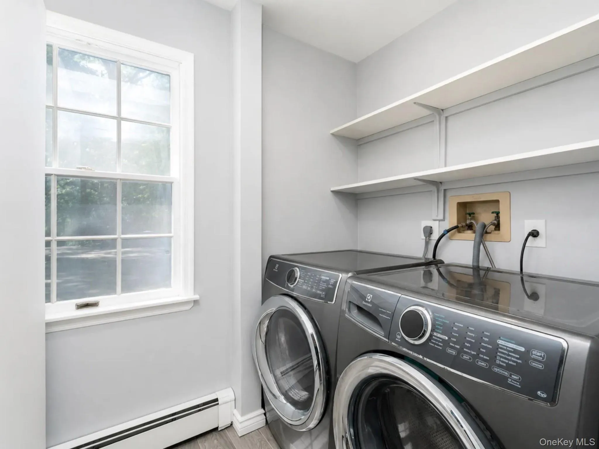 Main level laundry room with Electrolux front loading washer and dryer Main level laundry room with Electrolux front loading washer and dryer