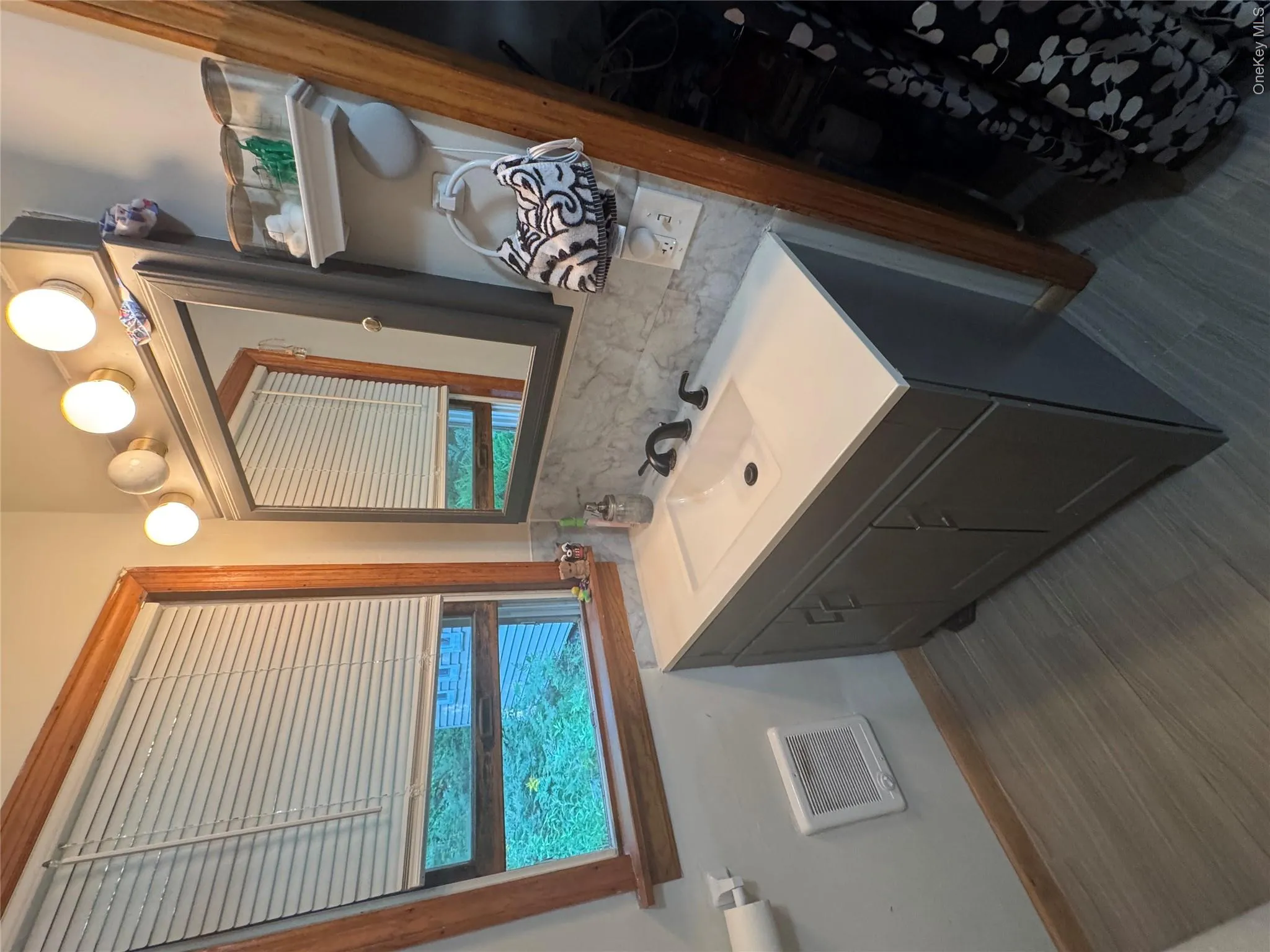 Wood-finish flooring with a modern vanity featuring a white countertop and integrated sink Wood-finish flooring with a modern vanity featuring a white countertop and integrated sink