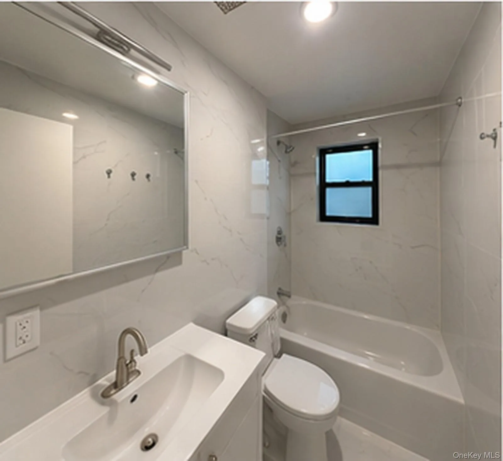 Bathroom featuring a white vanity with a rectangular sink, brushed nickel faucet, a medicine cabinet with integrated lighting, a toilet, and a bathtub with a shower and window Bathroom featuring a white vanity with a rectangular sink, brushed nickel faucet, a medicine cabinet with integrated lighting, a toilet, and a bathtub with a shower and window