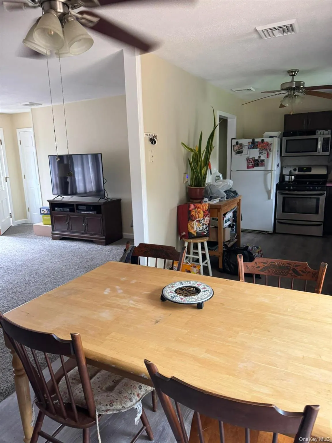 Carpeted dining area featuring a ceiling fan Carpeted dining area featuring a ceiling fan
