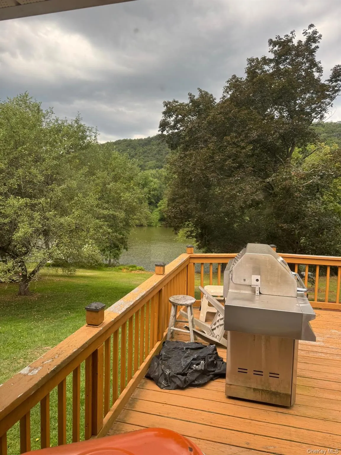 Deck with a grill, a lawn, a wooded view, and a water view Deck with a grill, a lawn, a wooded view, and a water view