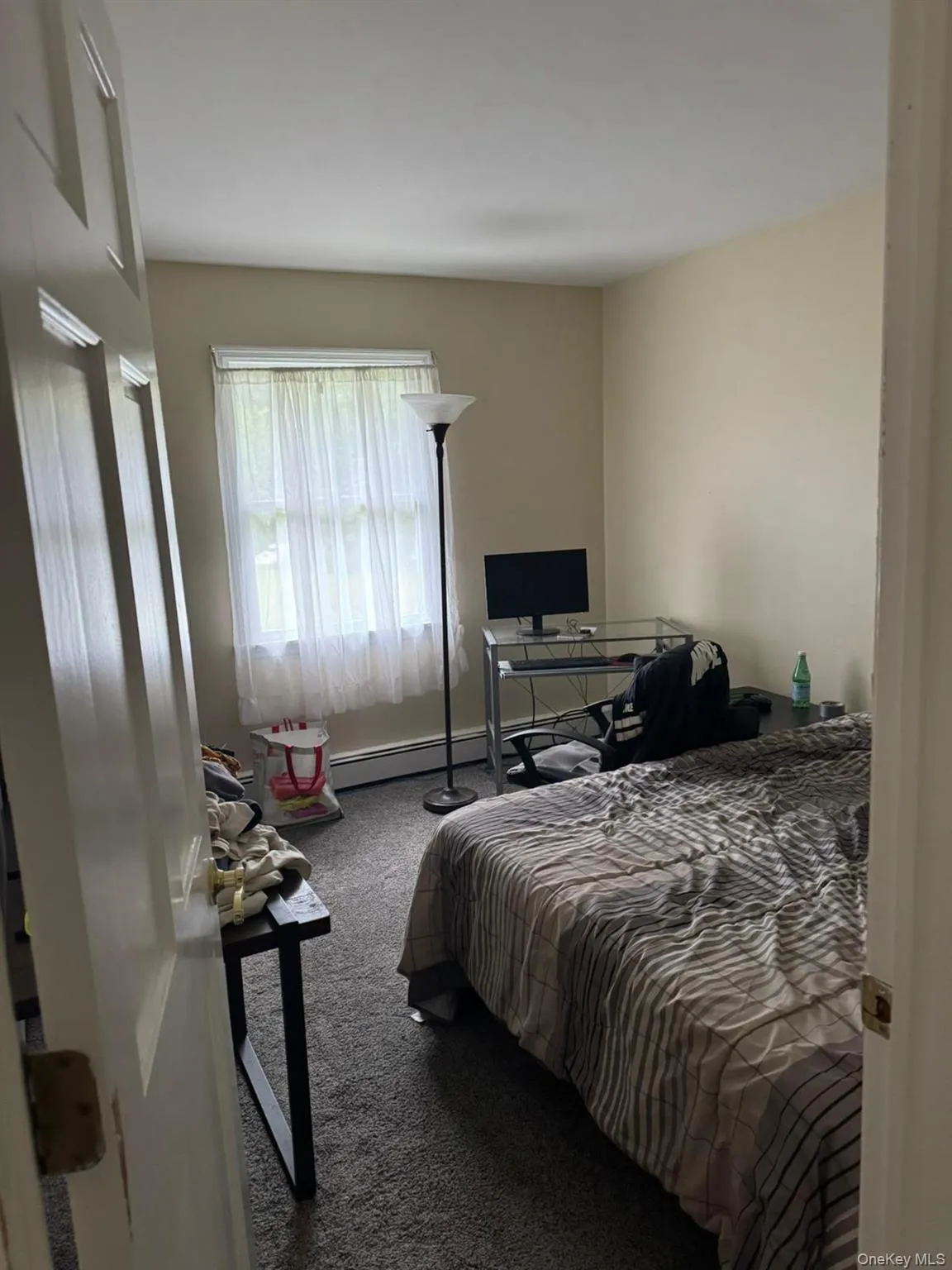 Bedroom with carpet flooring and a baseboard heating unit Bedroom with carpet flooring and a baseboard heating unit
