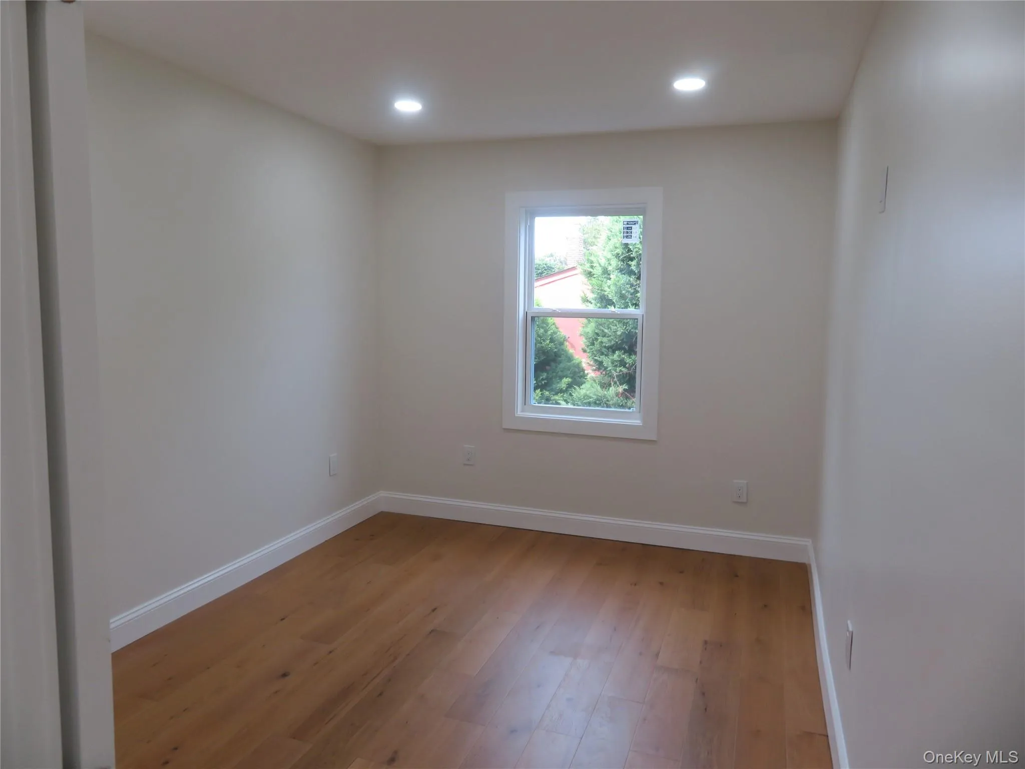 Bedroom 2 Recessed ceiling lighting, wood-finish flooring, white trim, and a double-hung window Bedroom 2 Recessed ceiling lighting, wood-finish flooring, white trim, and a double-hung window