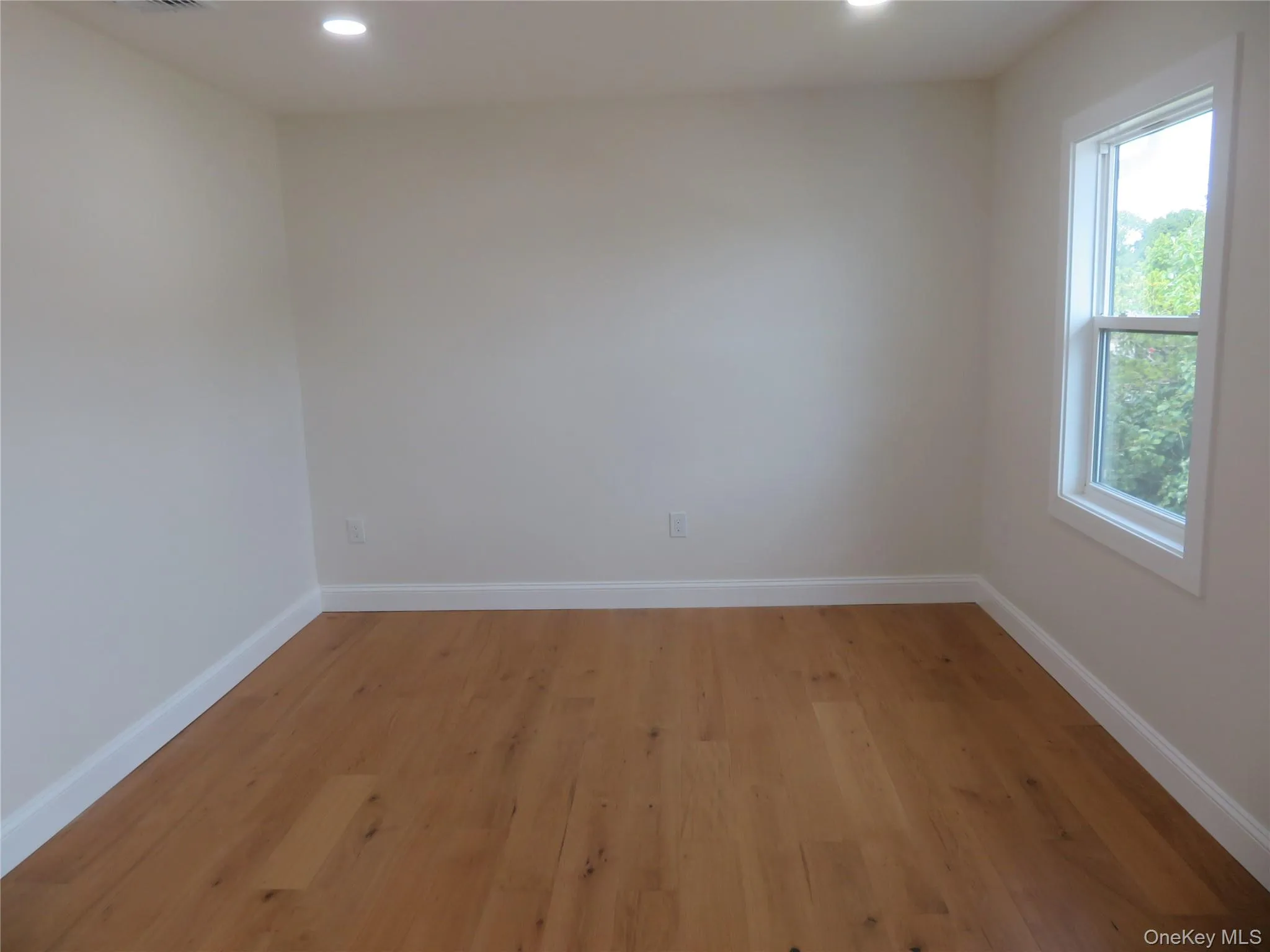 Bedroom 3, Wood-finish flooring, recessed ceiling lighting, single-hung window, and white trim Bedroom 3, Wood-finish flooring, recessed ceiling lighting, single-hung window, and white trim