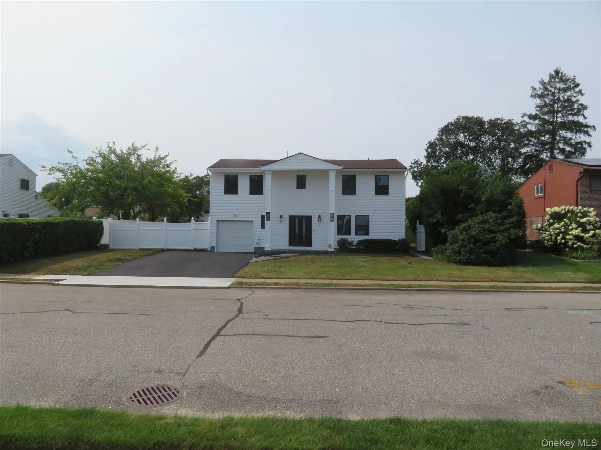 Two-story residence with white siding and dark-trimmed windows Two-story residence with white siding and dark-trimmed windows