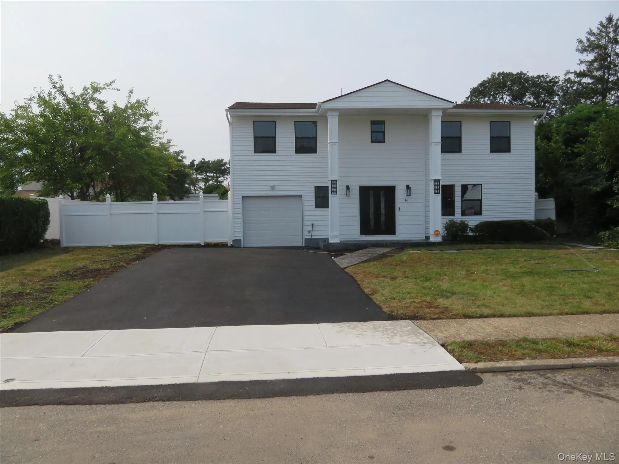 White siding exterior with a dark roof and prominent white columns White siding exterior with a dark roof and prominent white columns