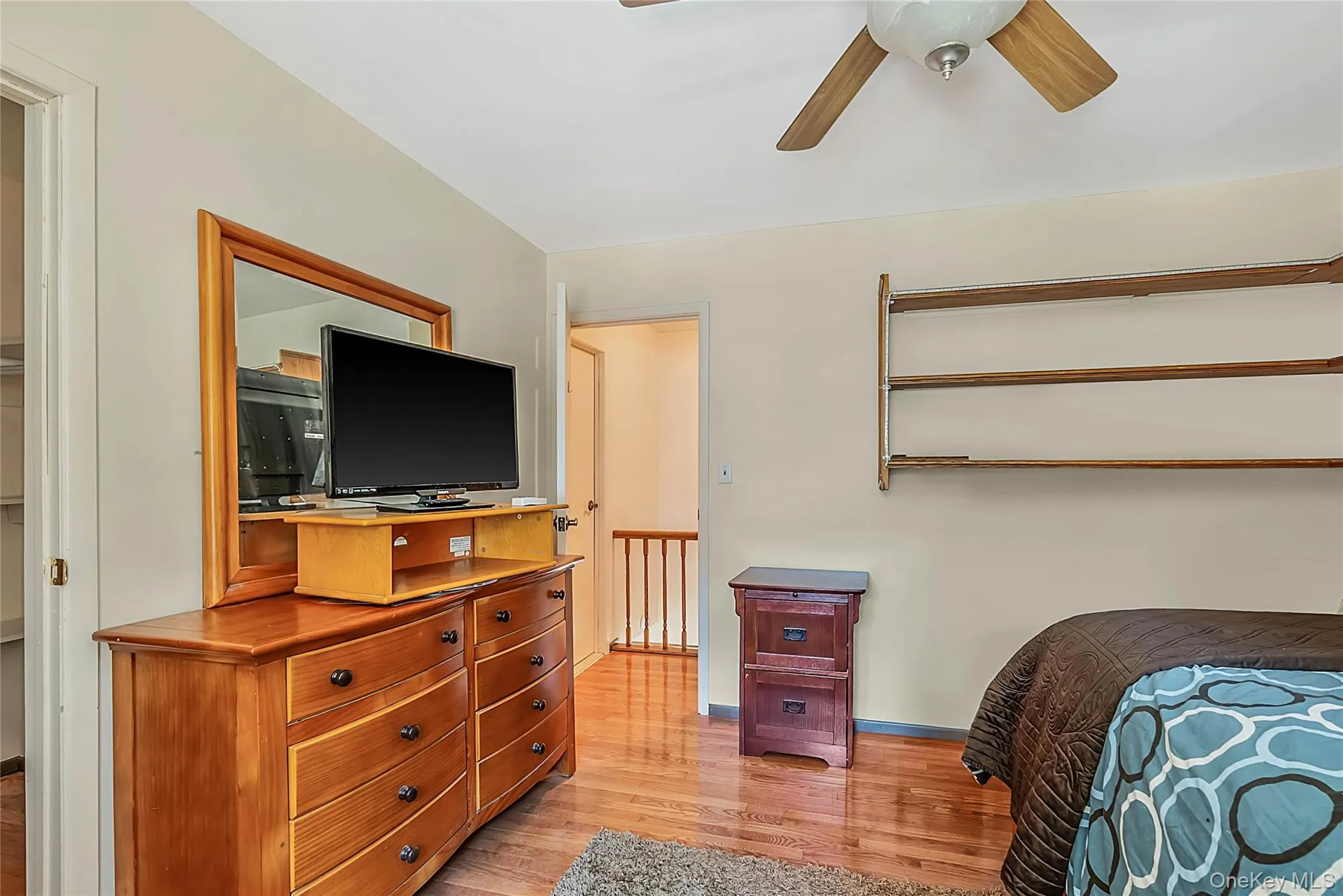 Hardwood flooring, ceiling fan with wood-finish blades, and built-in wall shelving Hardwood flooring, ceiling fan with wood-finish blades, and built-in wall shelving