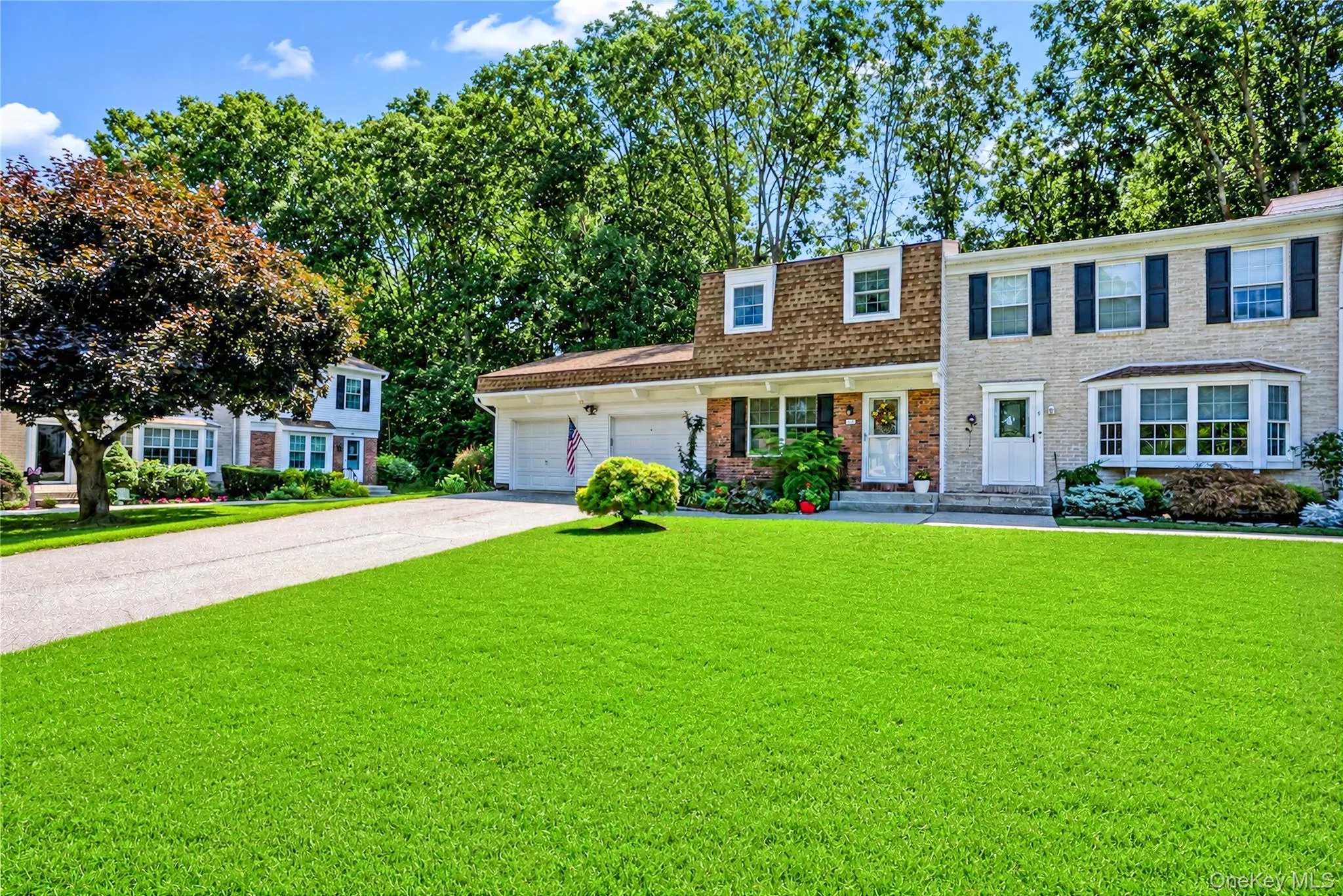 Brick and shingle exterior with white trim, bay window, and attached two-car garage Brick and shingle exterior with white trim, bay window, and attached two-car garage