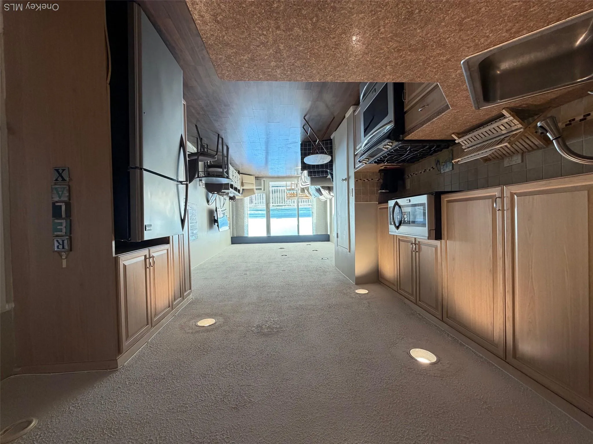 Kitchen with stove, recessed lighting, refrigerator, a textured ceiling, and dark wood-style flooring Kitchen with stove, recessed lighting, refrigerator, a textured ceiling, and dark wood-style flooring