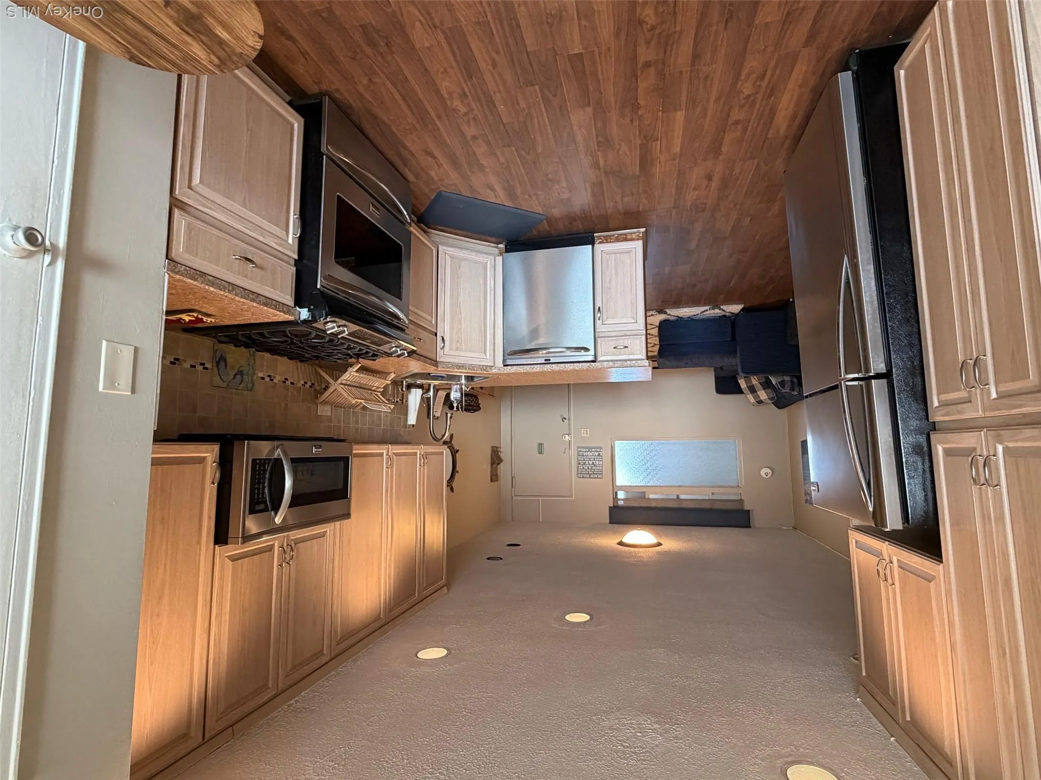 Kitchen featuring a peninsula, appliances with stainless steel finishes, dark wood-style floors, recessed lighting, and a textured ceiling Kitchen featuring a peninsula, appliances with stainless steel finishes, dark wood-style floors, recessed lighting, and a textured ceiling