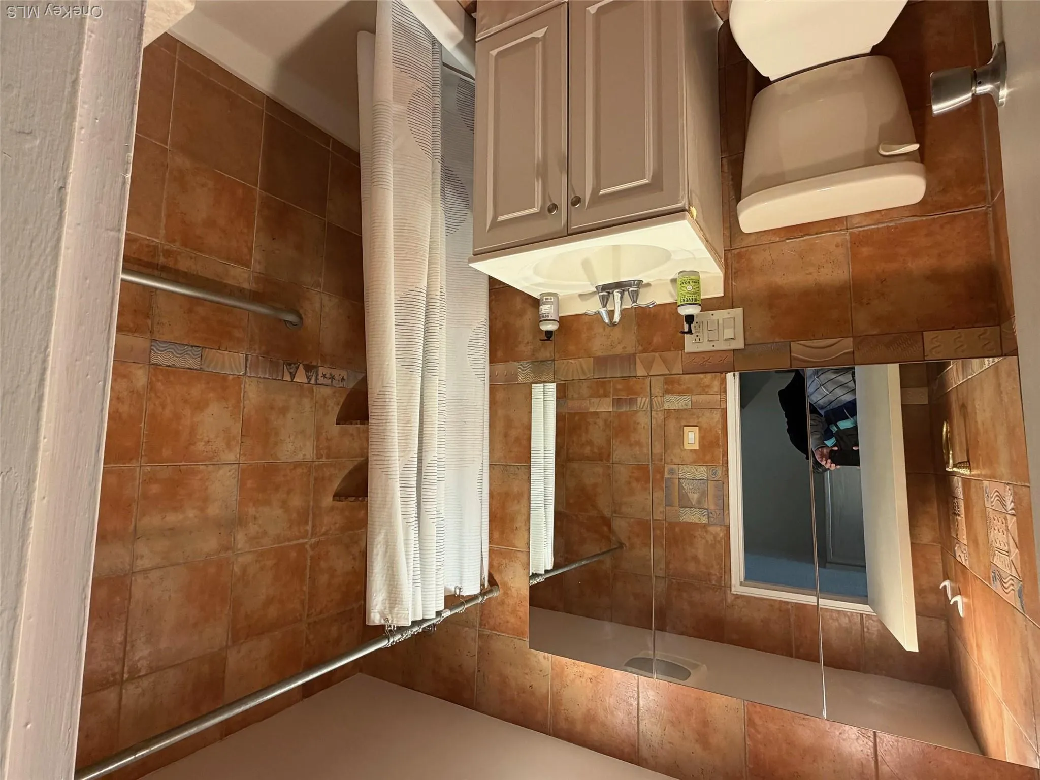 Bathroom with vanity, tile walls, and a shower stall Bathroom with vanity, tile walls, and a shower stall