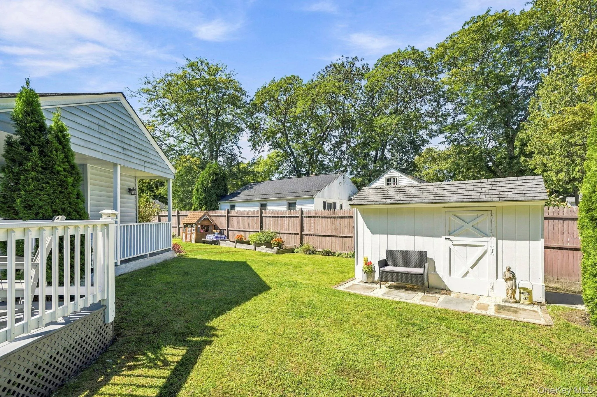 Expansive lawn with a wood privacy fence, a detached storage shed, and mature trees Expansive lawn with a wood privacy fence, a detached storage shed, and mature trees