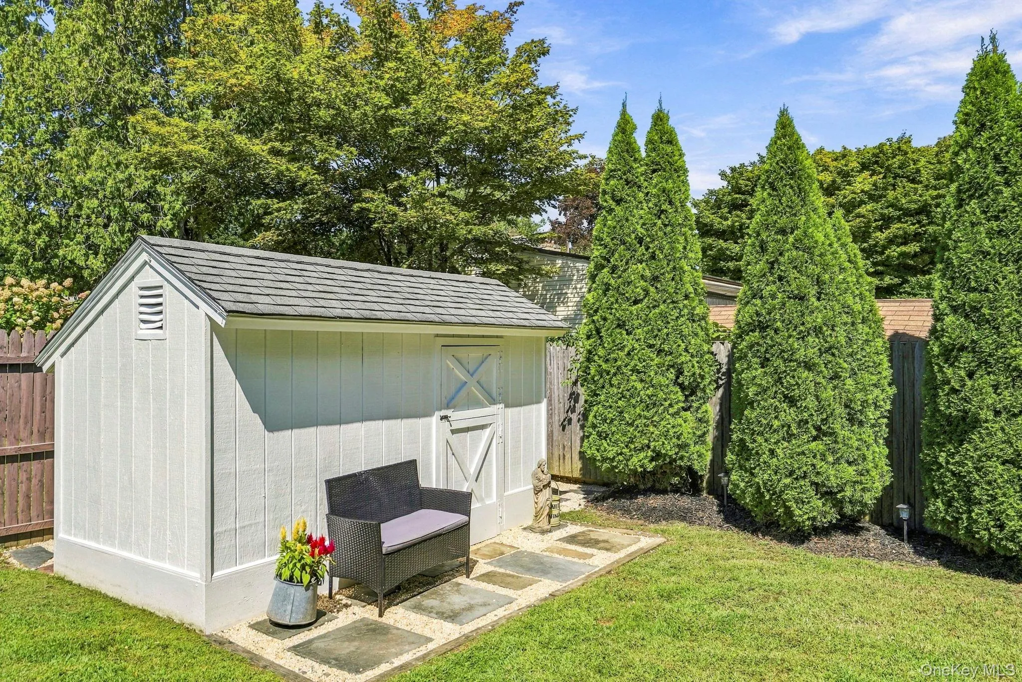 Storage shed with shingle roof, board and batten siding, and a barn-style door Storage shed with shingle roof, board and batten siding, and a barn-style door