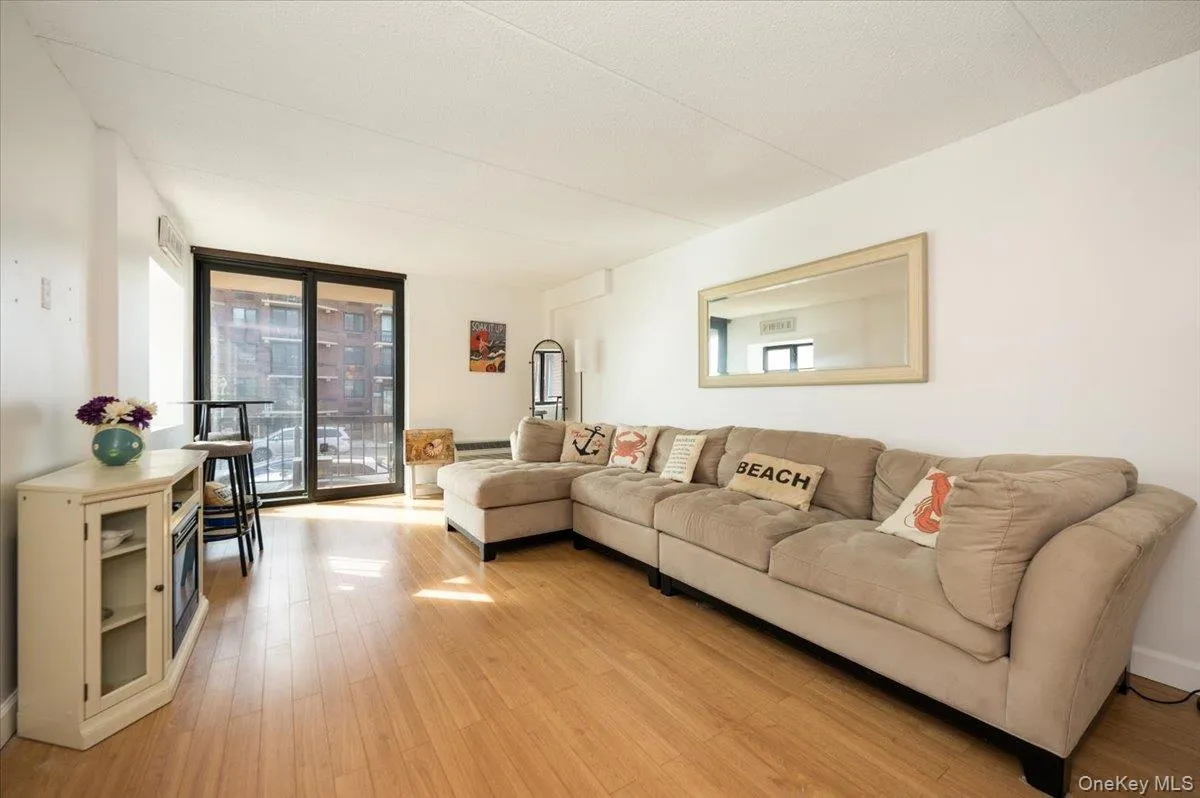 Living area with light wood-style floors, plenty of natural light, and expansive windows Living area with light wood-style floors, plenty of natural light, and expansive windows