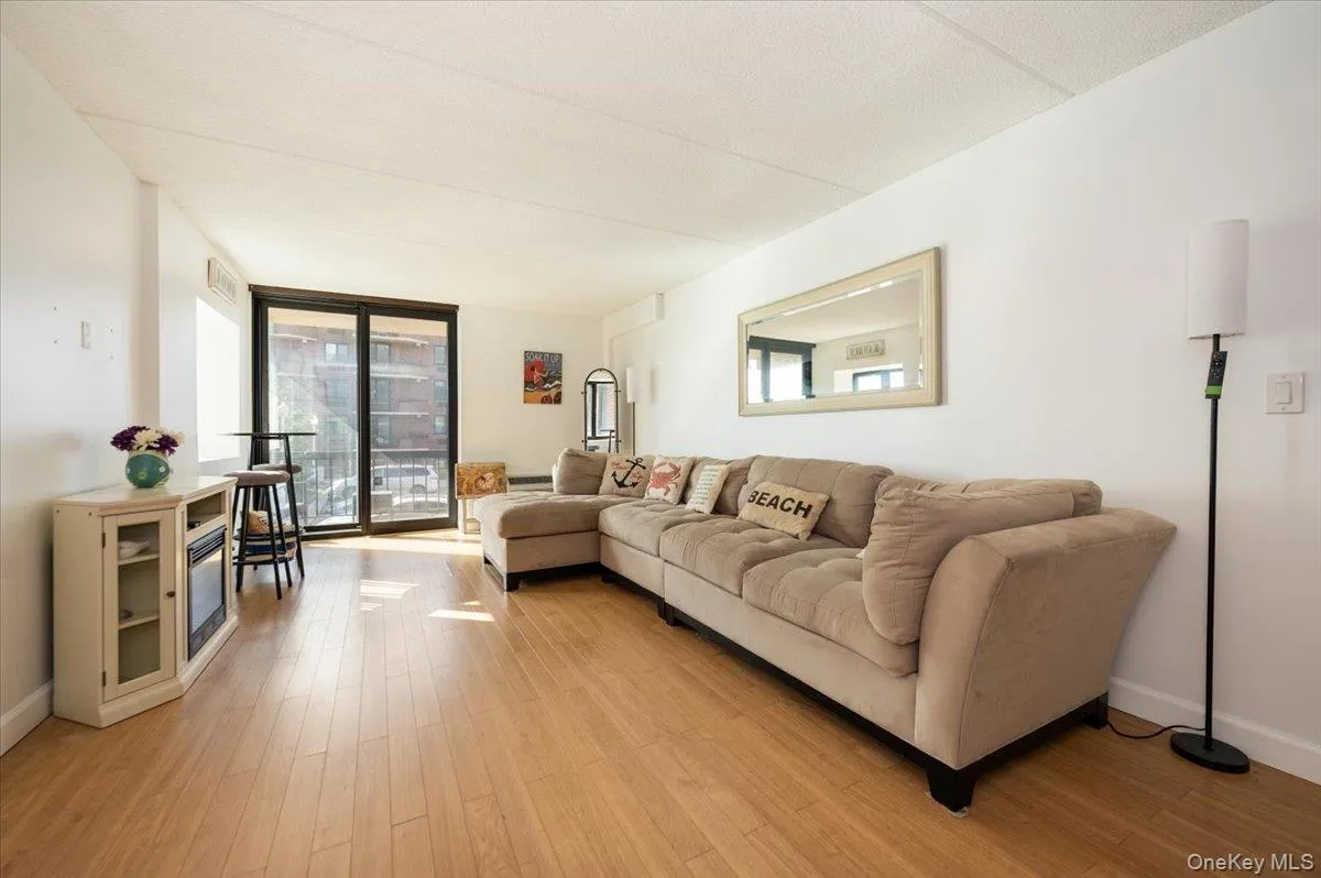 Living room featuring a wall of windows and light wood-style floors Living room featuring a wall of windows and light wood-style floors