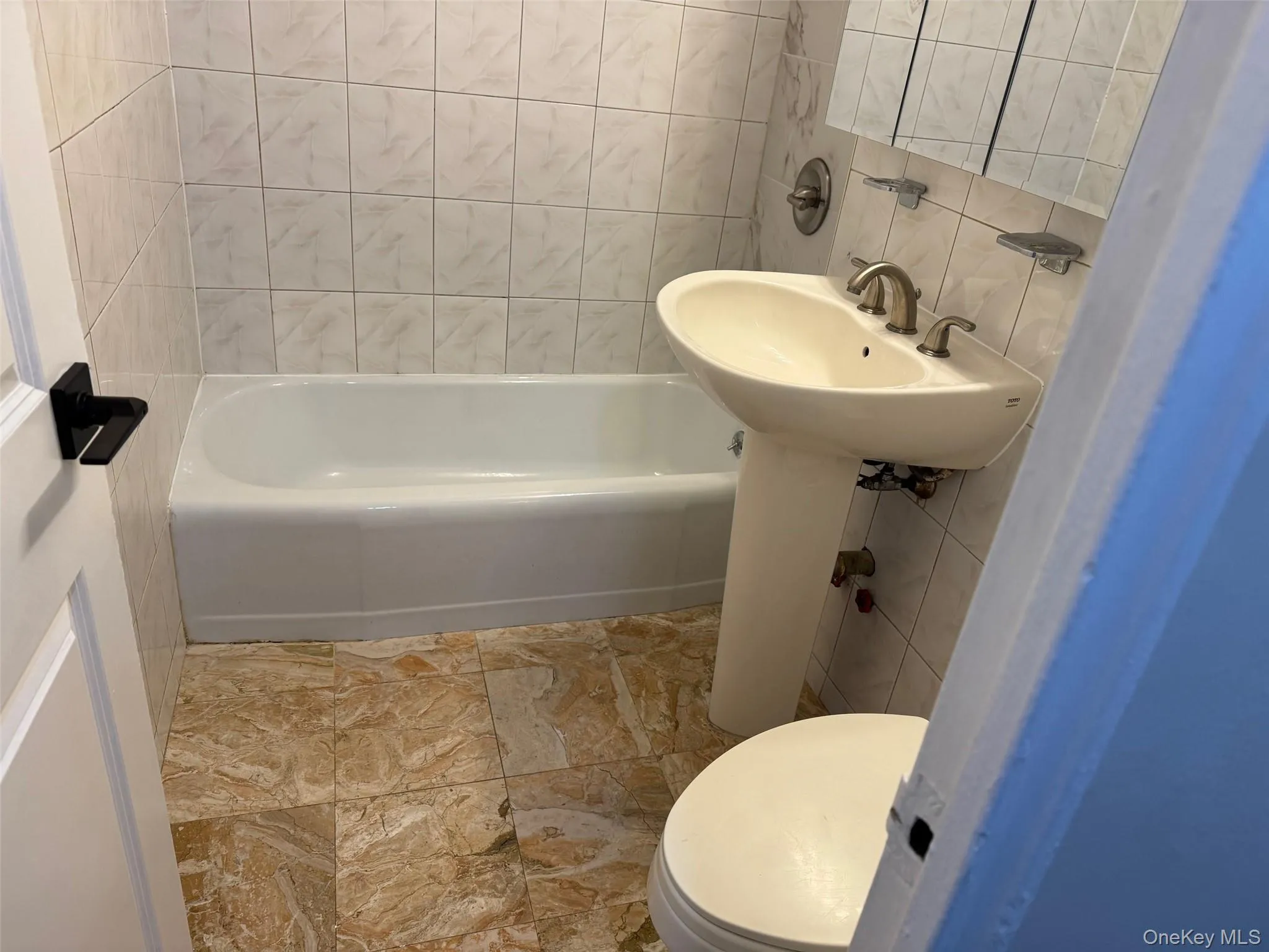 Full bathroom featuring tile walls and backsplash Full bathroom featuring tile walls and backsplash