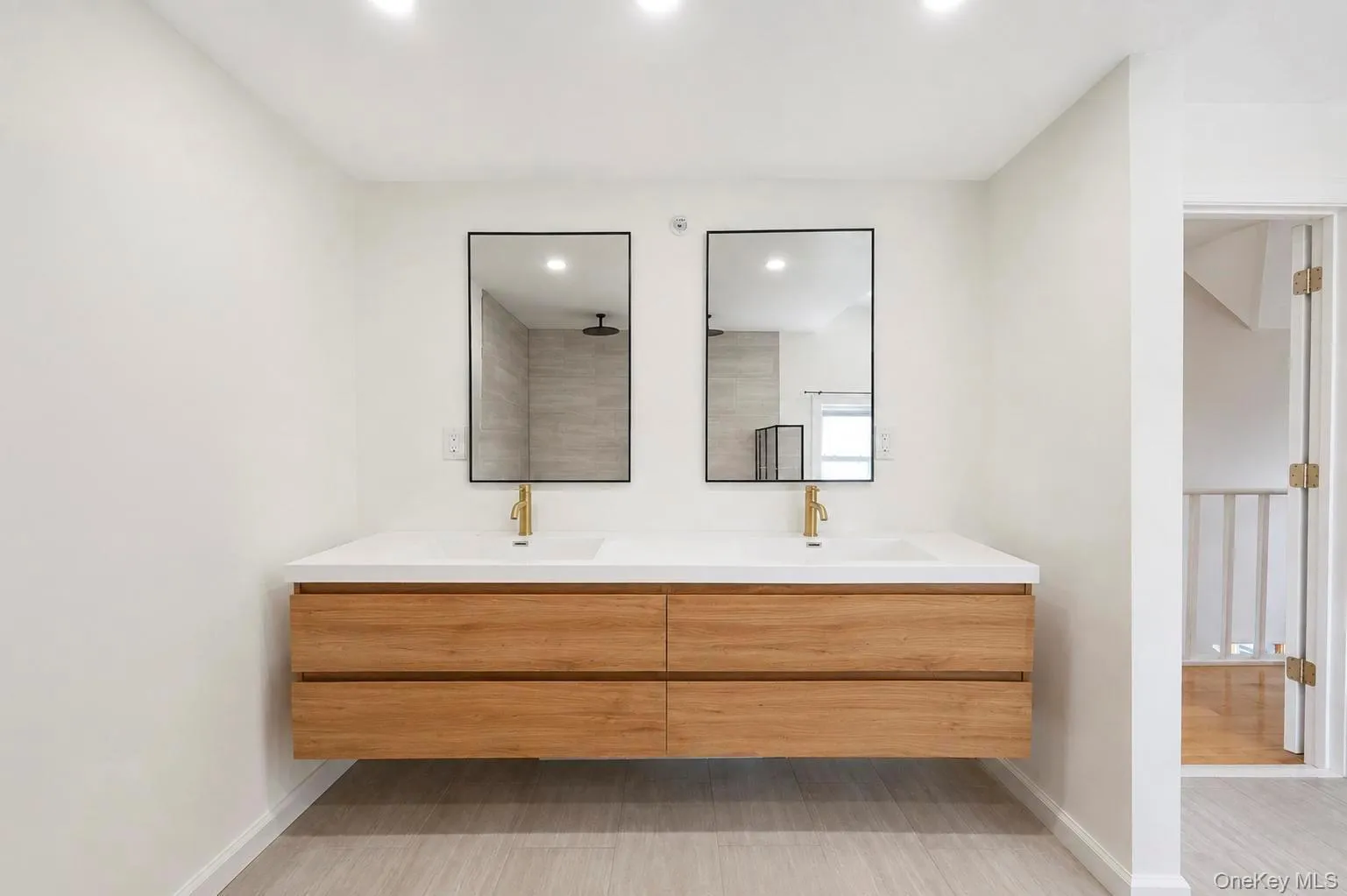 Floating double vanity with a white countertop, dual undermount sinks, and gold-finish faucets Floating double vanity with a white countertop, dual undermount sinks, and gold-finish faucets