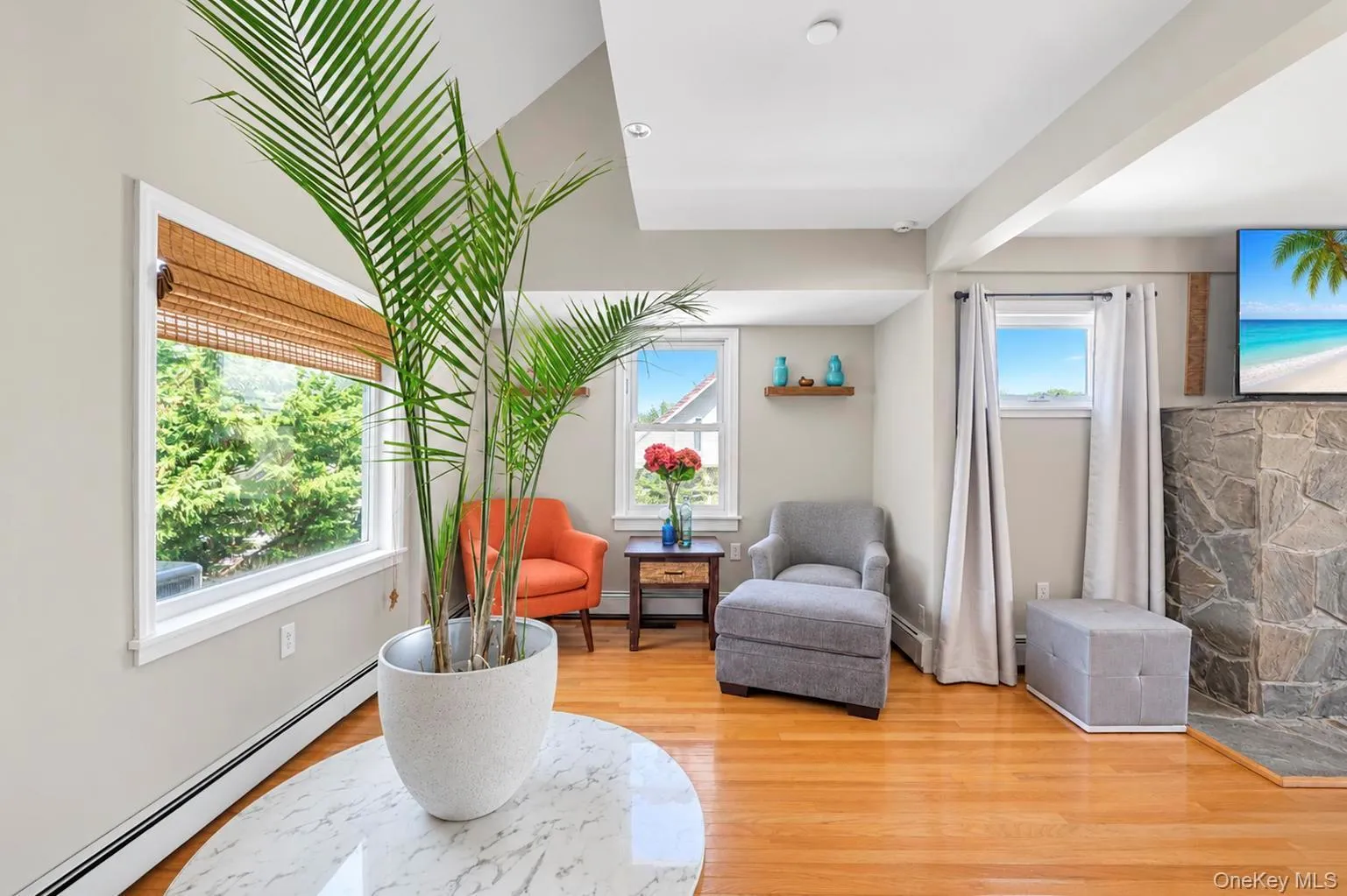 Hardwood flooring, recessed lighting, exposed beam, stone fireplace, and multiple windows with natural light Hardwood flooring, recessed lighting, exposed beam, stone fireplace, and multiple windows with natural light