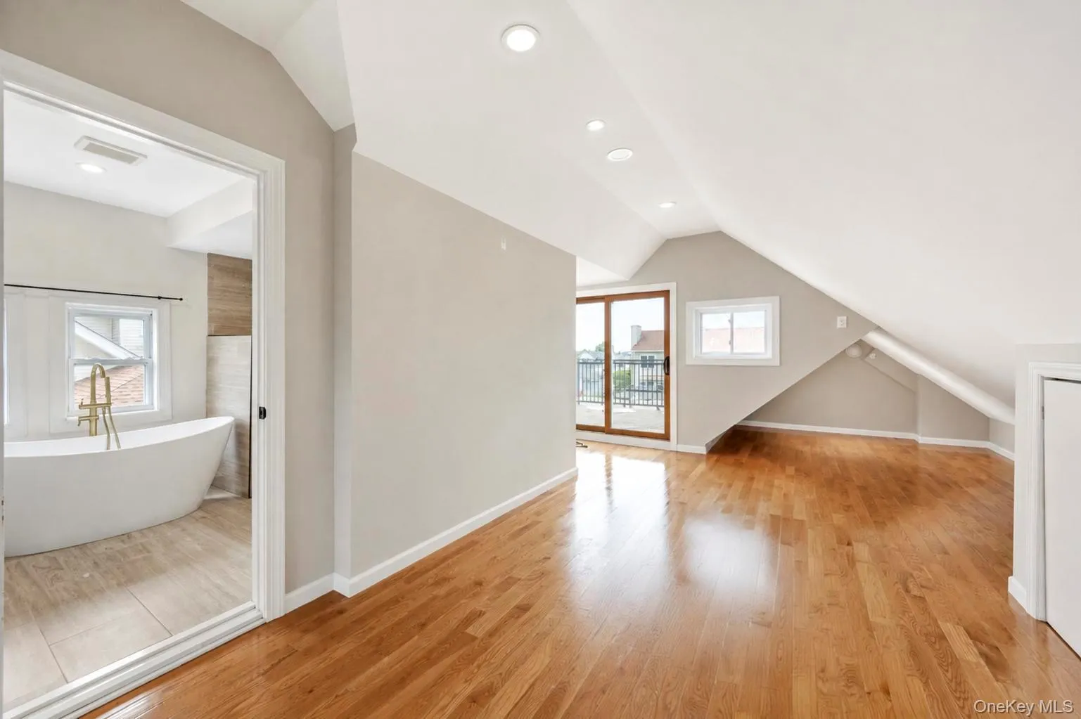 Hardwood flooring throughout, recessed lighting, and a sliding glass door to a private balcony Hardwood flooring throughout, recessed lighting, and a sliding glass door to a private balcony