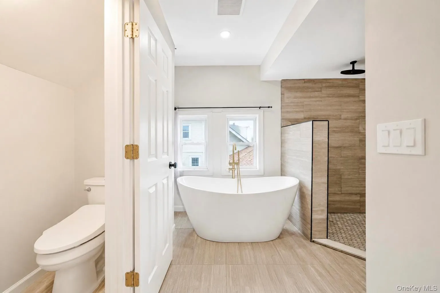 Freestanding soaking tub with a floor-mounted gold-finish faucet Freestanding soaking tub with a floor-mounted gold-finish faucet